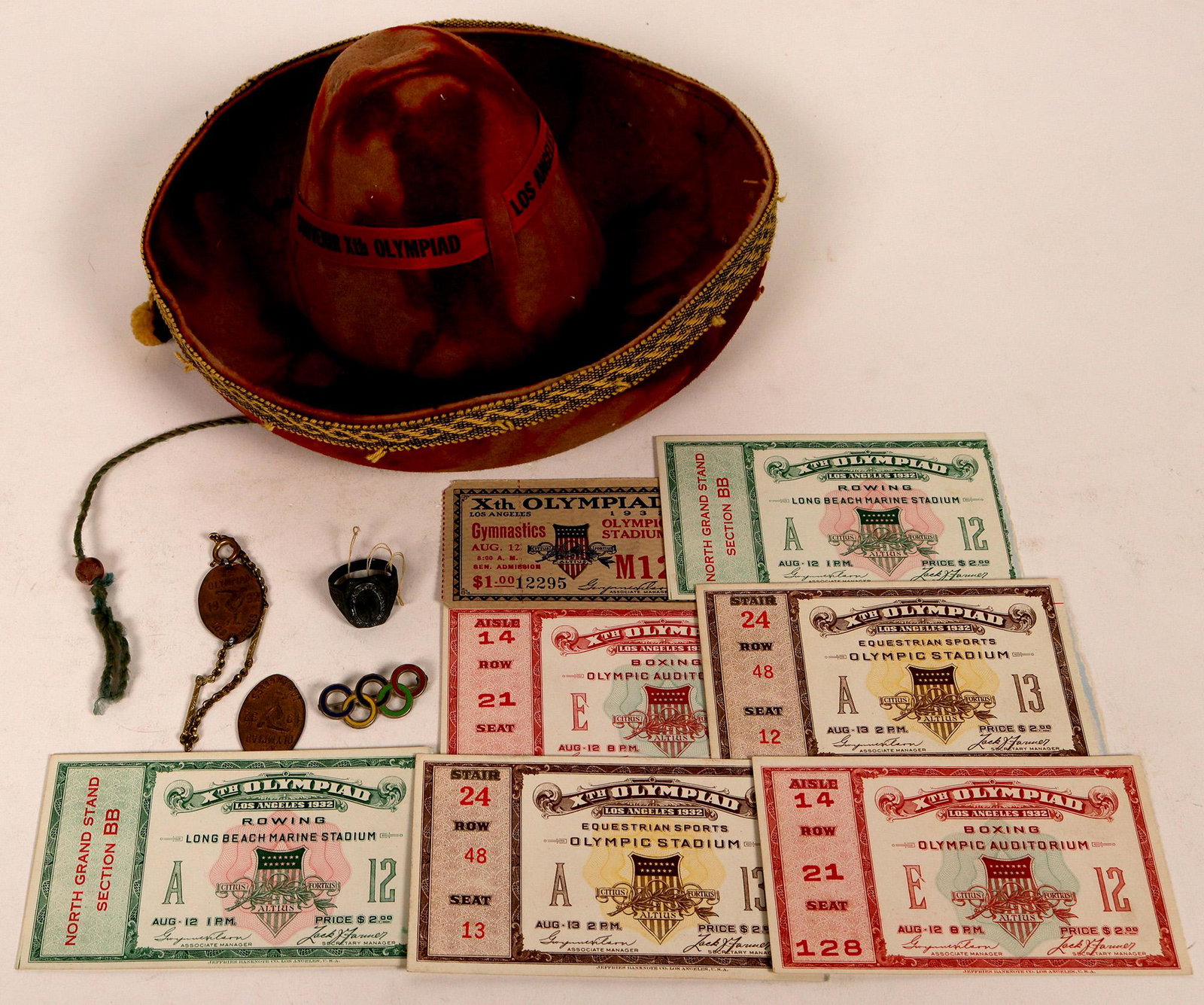 Olympic Souvenirs (122869): 1932 Olympics is the theme of this lot of used passes for various events including boxing, rowing, gymnastics and equestrian sports. There are also two pins a bracelet and a ring. Also included is a s
