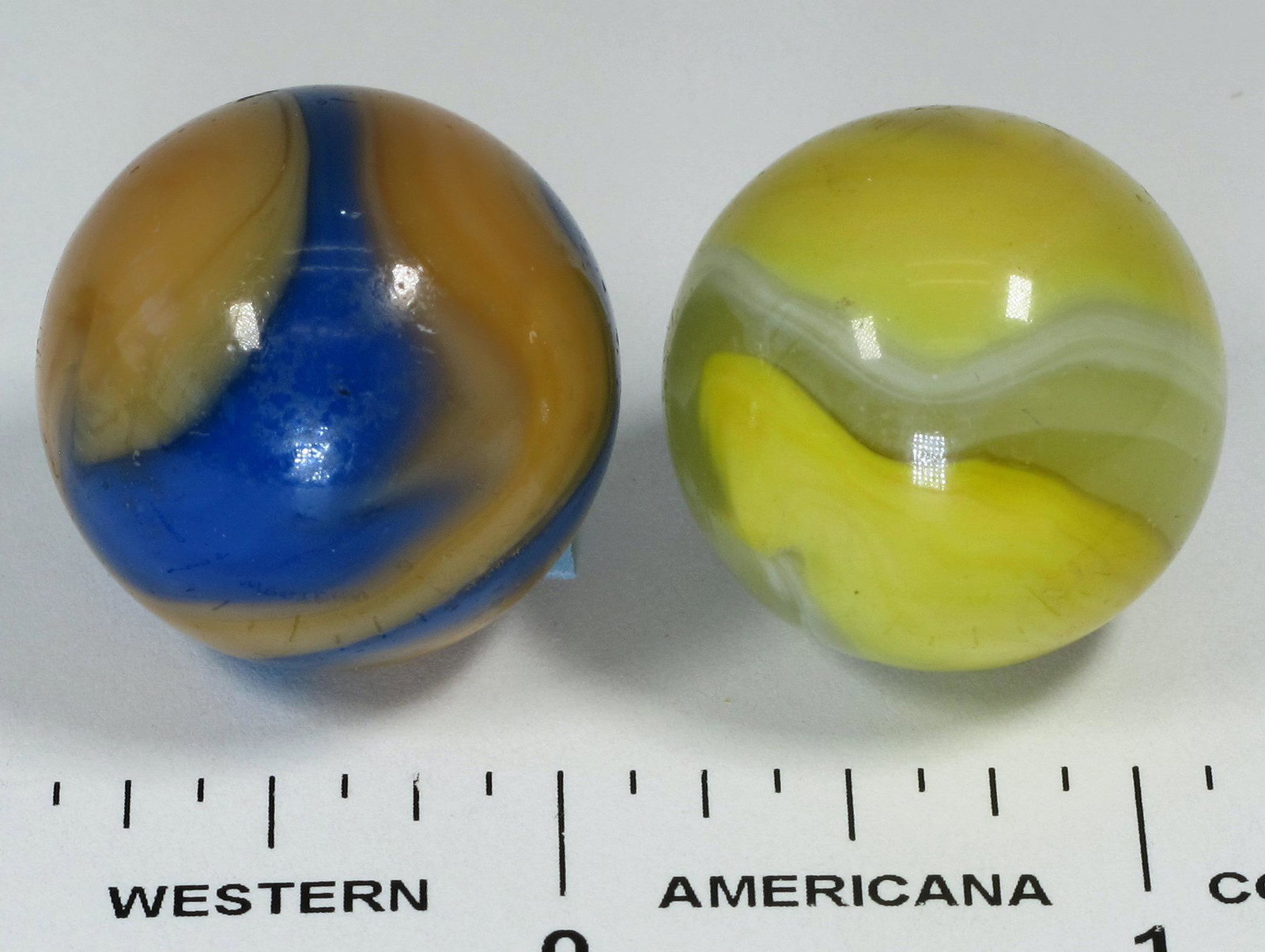 Akro Agate Corkscrew Marbles (2) - shooter size: 1. Akro Agate Blue/Salmon colored corkscrew 1" - mint condition, 2. Akro Agate Yellow /White/Clear corkscrew 1" - mint condition.Date: Country (if not USA): State: City: Provenance: