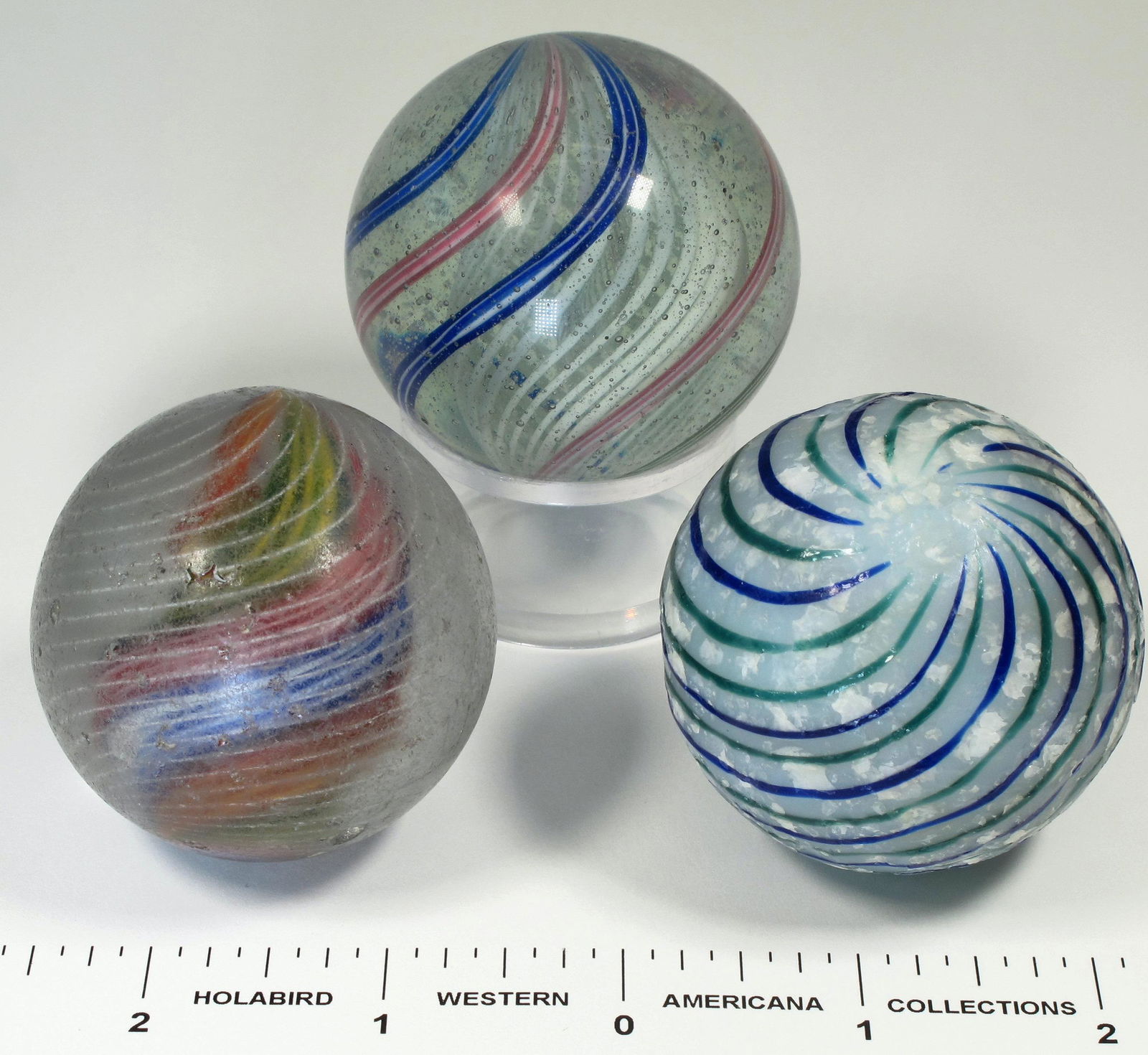 Large Swirl Marbles - 3 (125390): 1. 2" Latticino swirl. White core. Blue/white and red/white outer canes. Marble has been polished, pontils removed. displays well. 2. 1 7/8" divided core marble. Panels are green/yellow, blue/white, a