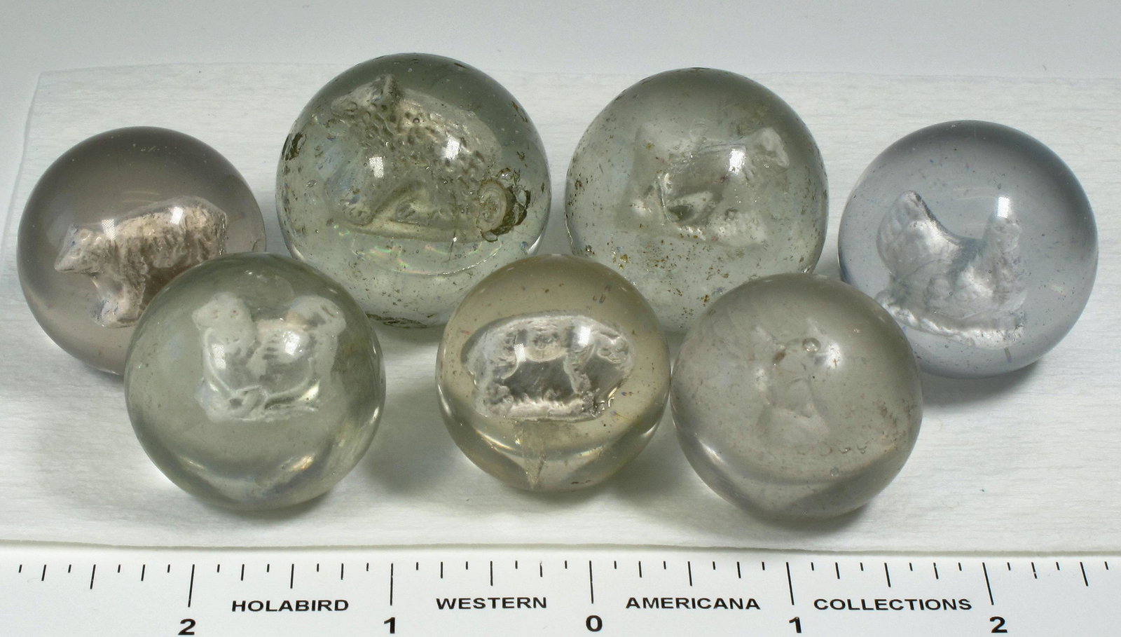 Sulphide Marbles - 7 (125391): 1. cow - 1 3/8". Bubble on one side of figure. Surface original, several tiny nick giving a hazy appearance to marble. 2. bear - 1 1/2" Figure has good detail. Surface has a couple of chips and severa