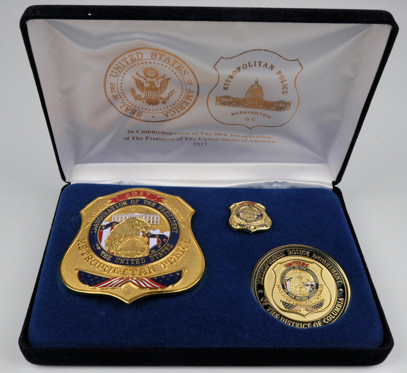 58th Unaugurational Metro Police Bade (125343): Made by Collinson, solid brass, pure gold plate. This is a complete presentation box w/Badge, lapel pin (mini badge) and Challenge coin, satin liner, gold foil on satin and outside of box. Initially i