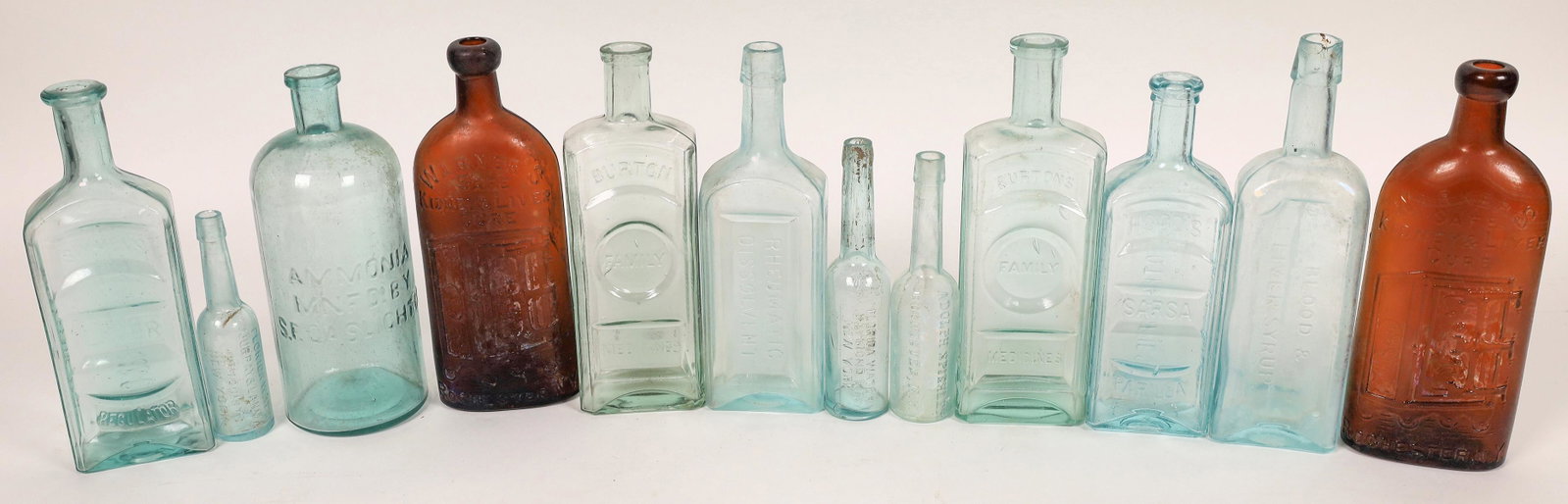 Antique Cures, Sarsaparilla etc. Group (126595): A dozen antique bottles (mostly the large sized "cures", roughly 9-10" tall). Two Warner's Safe cures; two Burtons Family Med.; Kennedy Rhumatic; Scoville Blood; Hoods Sarsp; Simmons Liver Regulator; 