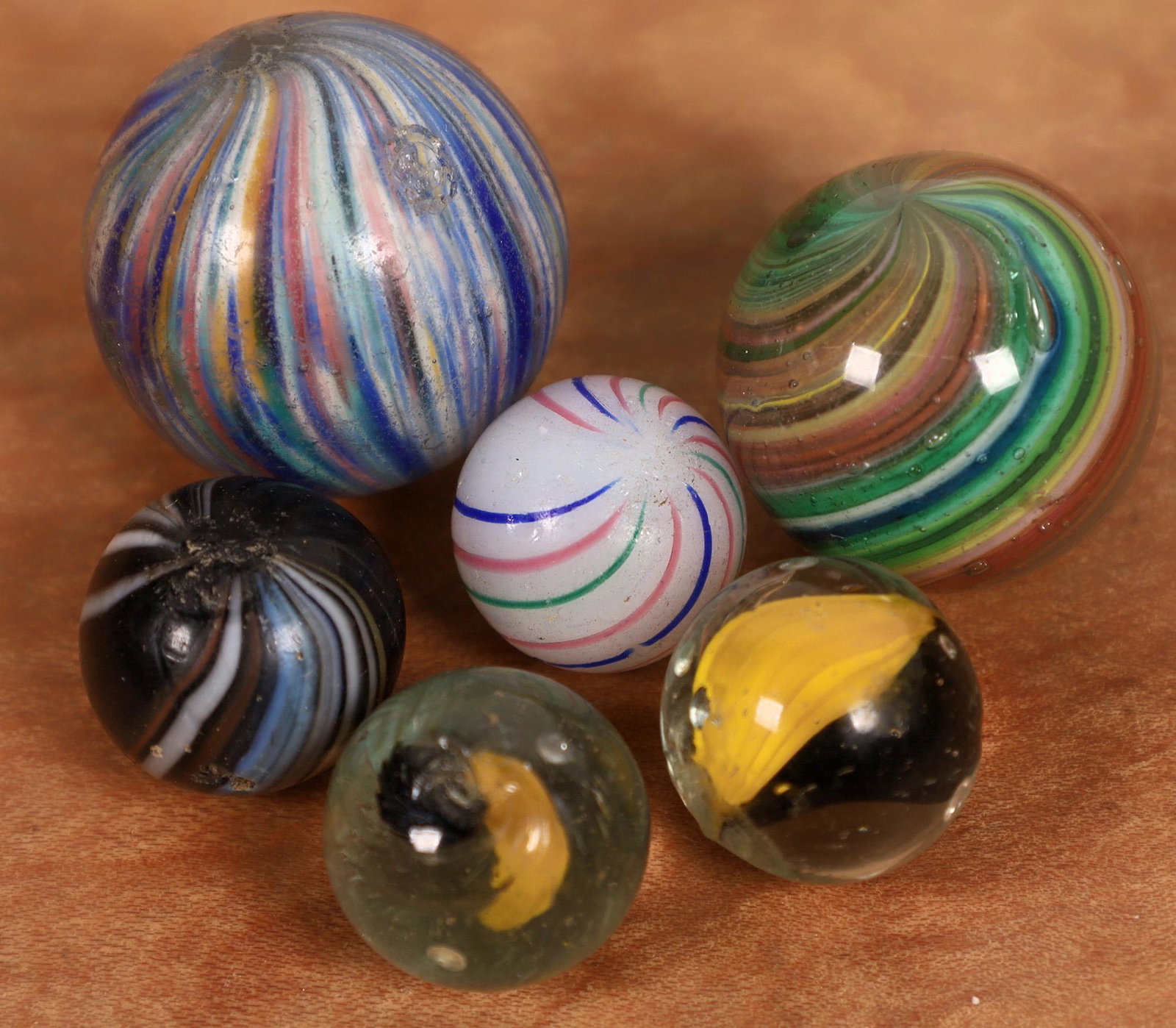 Clambroth, Banded swirl, Ribbon swirls (2), Onionskins: 1. 1/2" white base clambroth. Blue, red and green strands. One red and one green stand missing. Three tiny nicks otherwise surface is clean. 2. 5/8" Indian type banded swirl. Dark base, white and blue