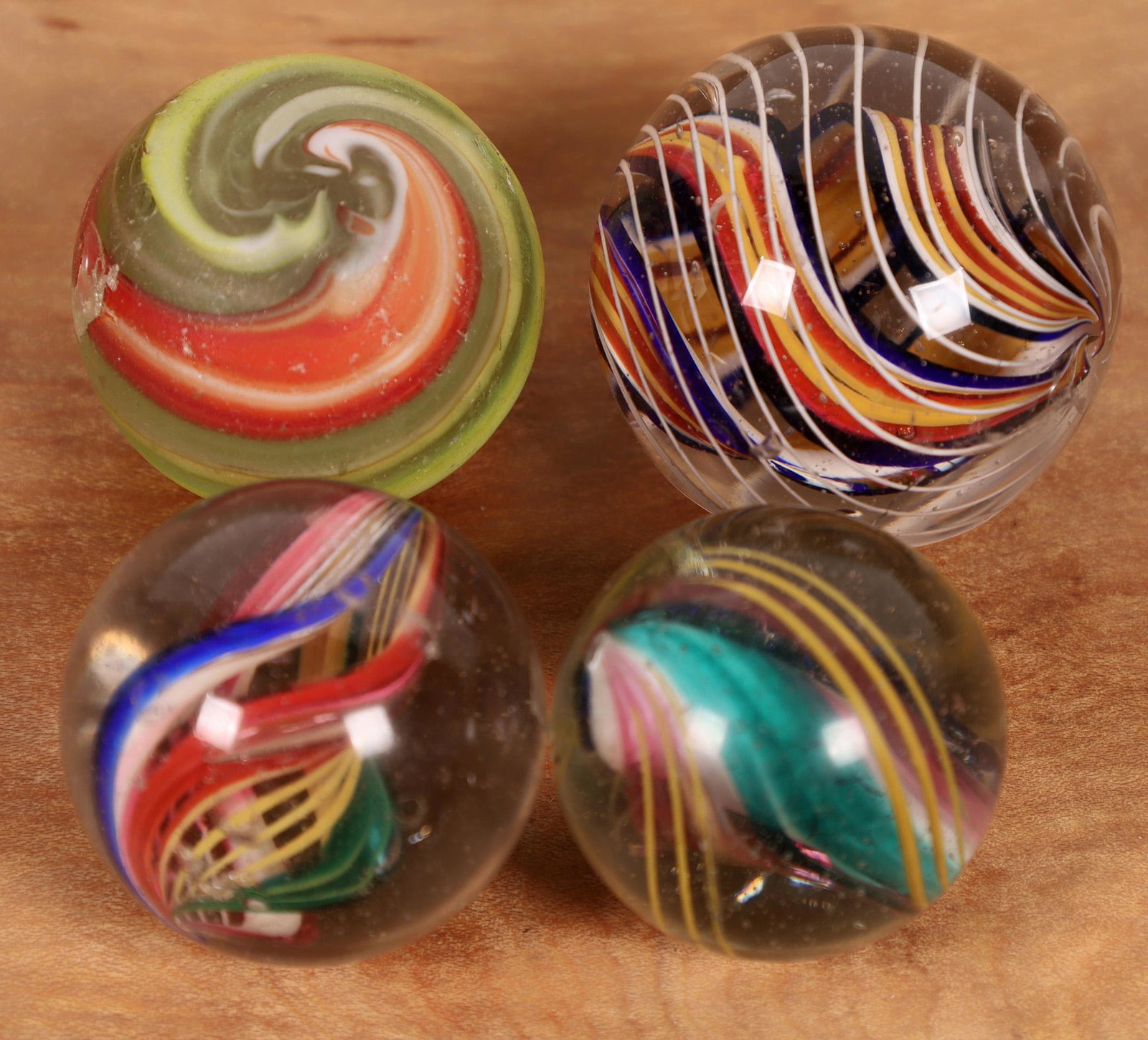 Divided core, Open ribbon core, Solid core, Corkscrew: 1. 1 5/8" Divided core. Interior ribbons are blue/white/red/yellow. Single white strand outer banding. Marble has been polished and some surface roughness still exists. 2. 1 1/2" open ribbon core. One