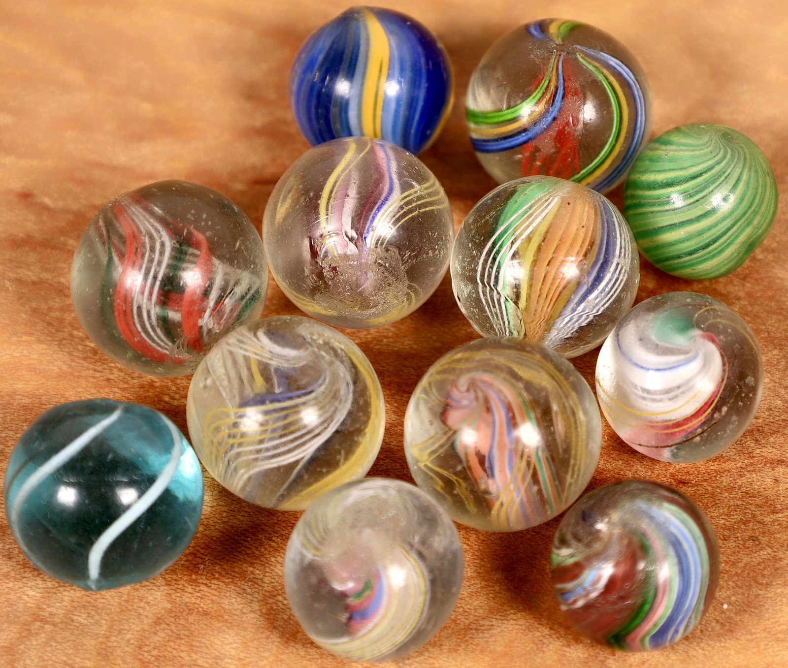 Handmade swirls (12) [127826]: Nice selection of handmade swirls 1/2" to 5/8" in size. All are mint to mint minus because of a few surface scratches or a couple of flea bites. The group contains onionskins, coreless, divided core, 