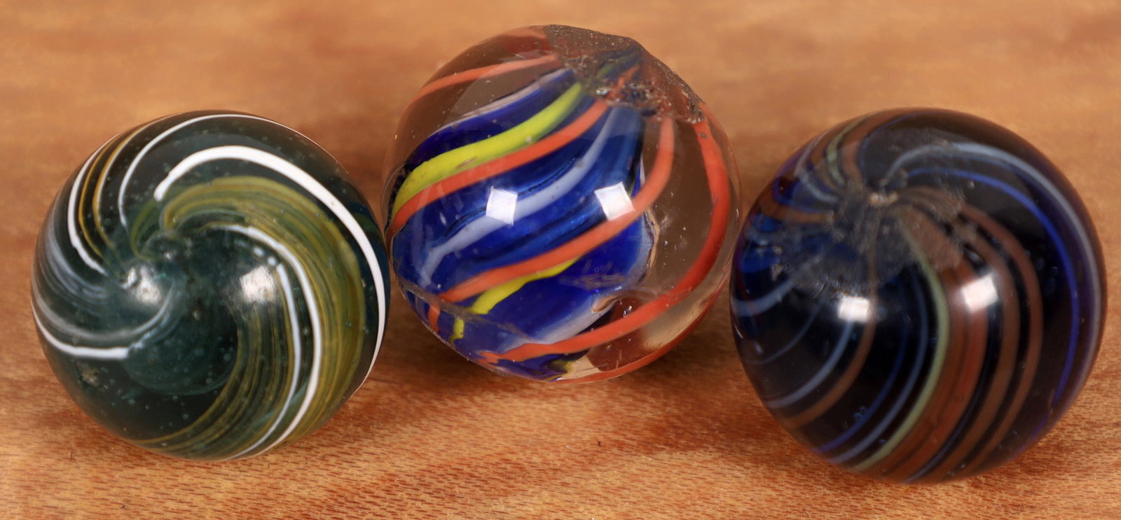 Outer band swirls (2), Solid core swirl (1) [127823]: 1. 5/8" Banded swirl with white and yellow banding on the surface and another set of loosely configured yellow and white canes subsurface. Condition is mint. 2. 5/8" banded swirl with blue, white and 