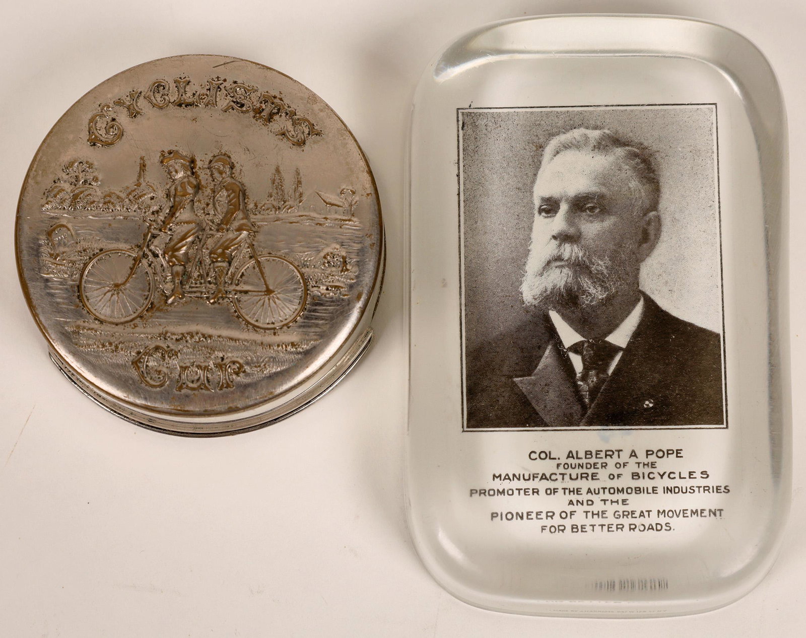 Bicycle Collectibles [129724]: Three items with a bicycle theme. First we have a paperweight with a photo of former Union officer, importer and bicycle manufacturer Albert A. Pope. Next , a cyclist's collapsible metal cup and last 