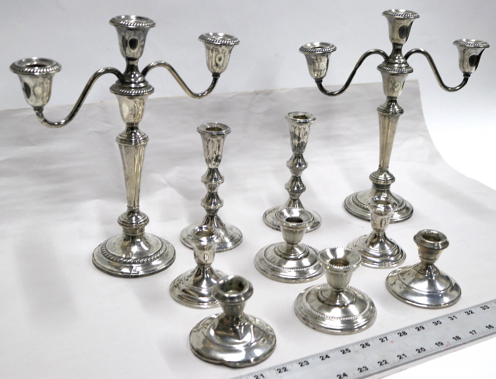 Sterling Candelabra Group [131503]: Two 12" 3 candle by Gorham; two single candle 6.5" tall by Gorham; Six single candle 3" tall, three with different patterns. Well used some damage to each piece. All are weighted therefor the exact we