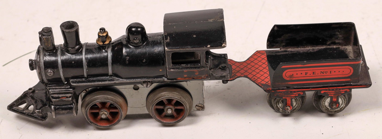 Cast Iron Steam Locomotive and Tender [133081]: Black with red trim. Tender marked "F.E. No. 1" No damage. Excellent condtion.Date: 1920sCountry (if not USA): State: City: Provenance: Gary Nelson Railroad Collection
