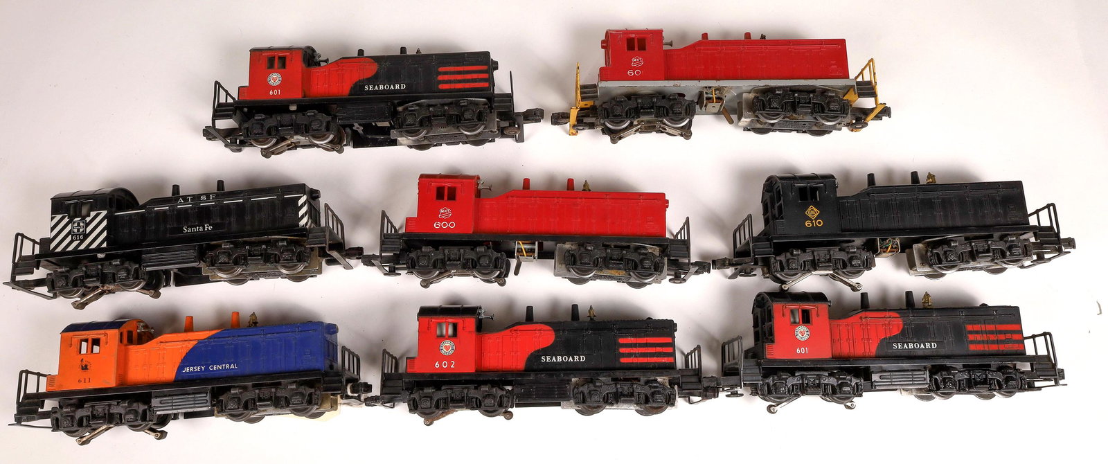 Lionel Diesel Switchers - 8 [133121]: 1) #611 Jersey Central, orange and blue. 2) #616 AT&SF Atchison, Topeka and Santa Fe, black with white/black stripes. 3) #602 Seaboard, company logo on cab, red and black. 4) #610 Erie with company lo