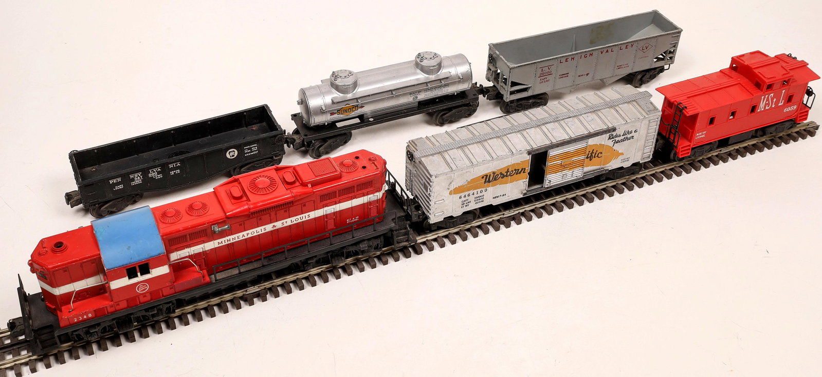 Lionel GP7 Diesel with 5 Cars [133192]: #2348 Minneapolis & St. Louis, Red, with white stripe, blue roof. 1) Gondola, Penn RR, black. 2) Western Pacific Box Car with operating doors, silver with yellow feather. 3) Lehigh Valley Bottom Dump.