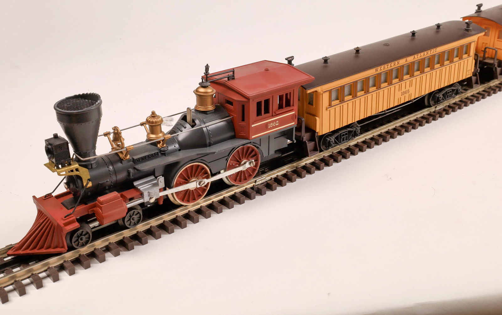 Lionel Steam "The General" Locomotive and 2 Cars: #1862 Loco 4-4-0. "General" on both sides of boiler, gray with gray stack, tuscan wheels, pilot in cab and brass trim. Green Tender marked W&A.R.R. #1862T Simulated wood. Car 1: Mail Baggage Car #1866