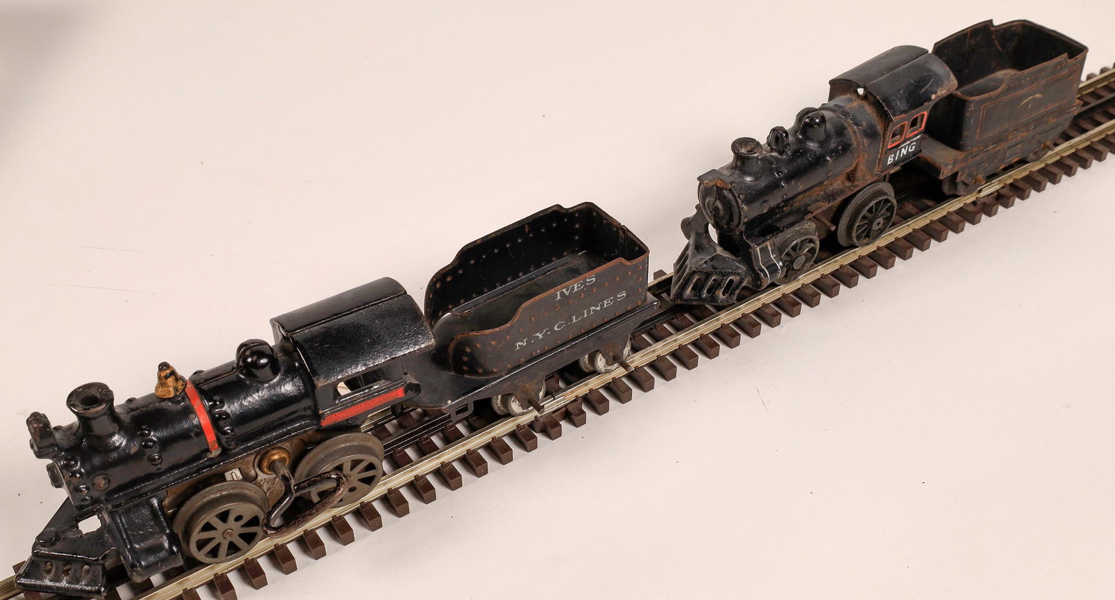 Wind-Up Locomotive and Tenders - 2 [133075]: 1) Cast Iron Loco, black and red. Tenders are tin. Unmarked. Ives. 2) Black Loco, with red trim, marked Bing on cab. Printing on tender is illegible. No damage. Good condition.Date: 1900-1920Country (