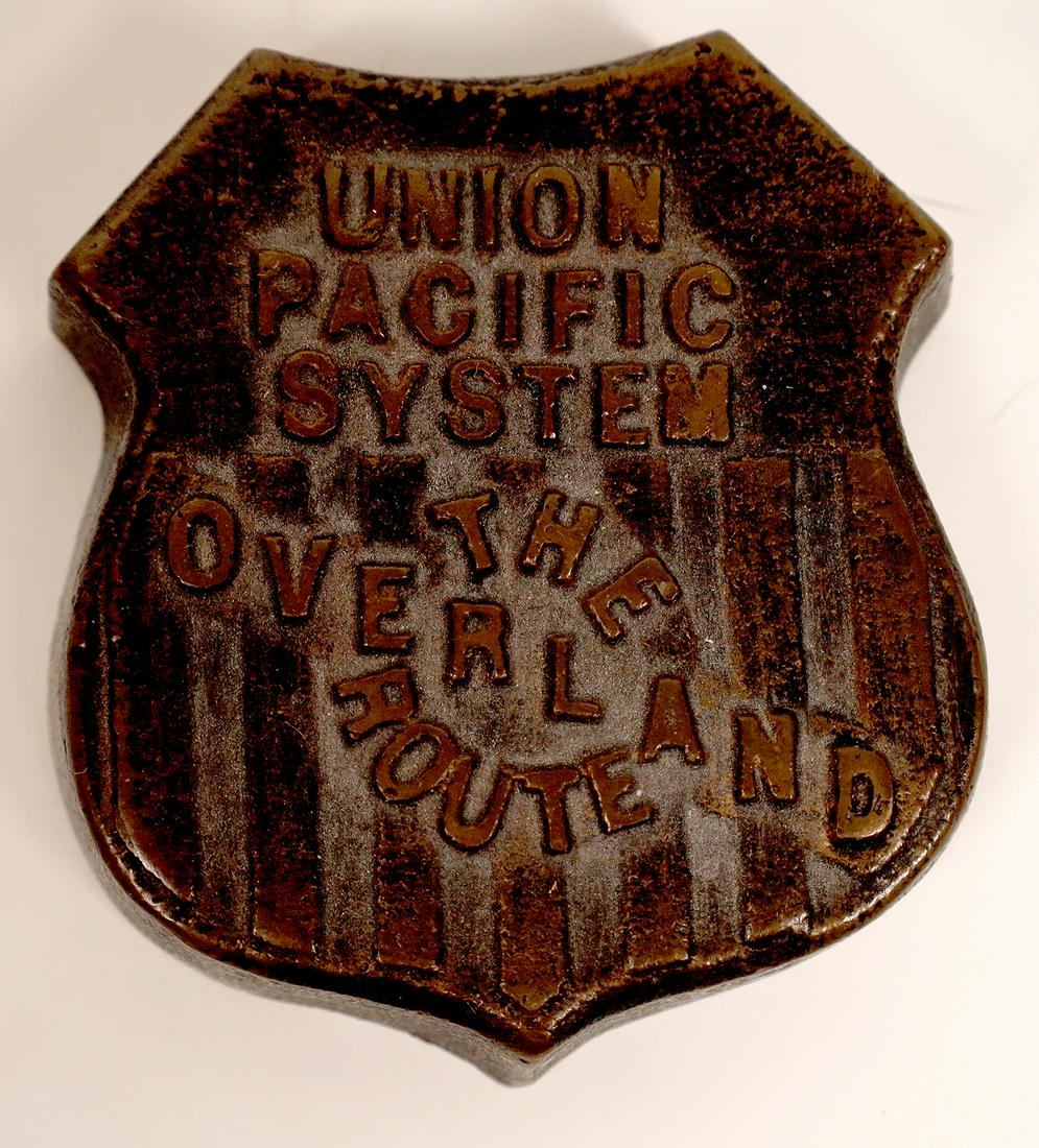 Union Pacific Railroad Brass Display Logo [131320]: Embossed Union Pacific Railroad Brass or Bronze Shield "Union Pacific System / The Overland Route" 2.5" x 2.5" Rare. Possibly an early paperweight. Very Attractive.Date: c1920Country (if not USA): Sta