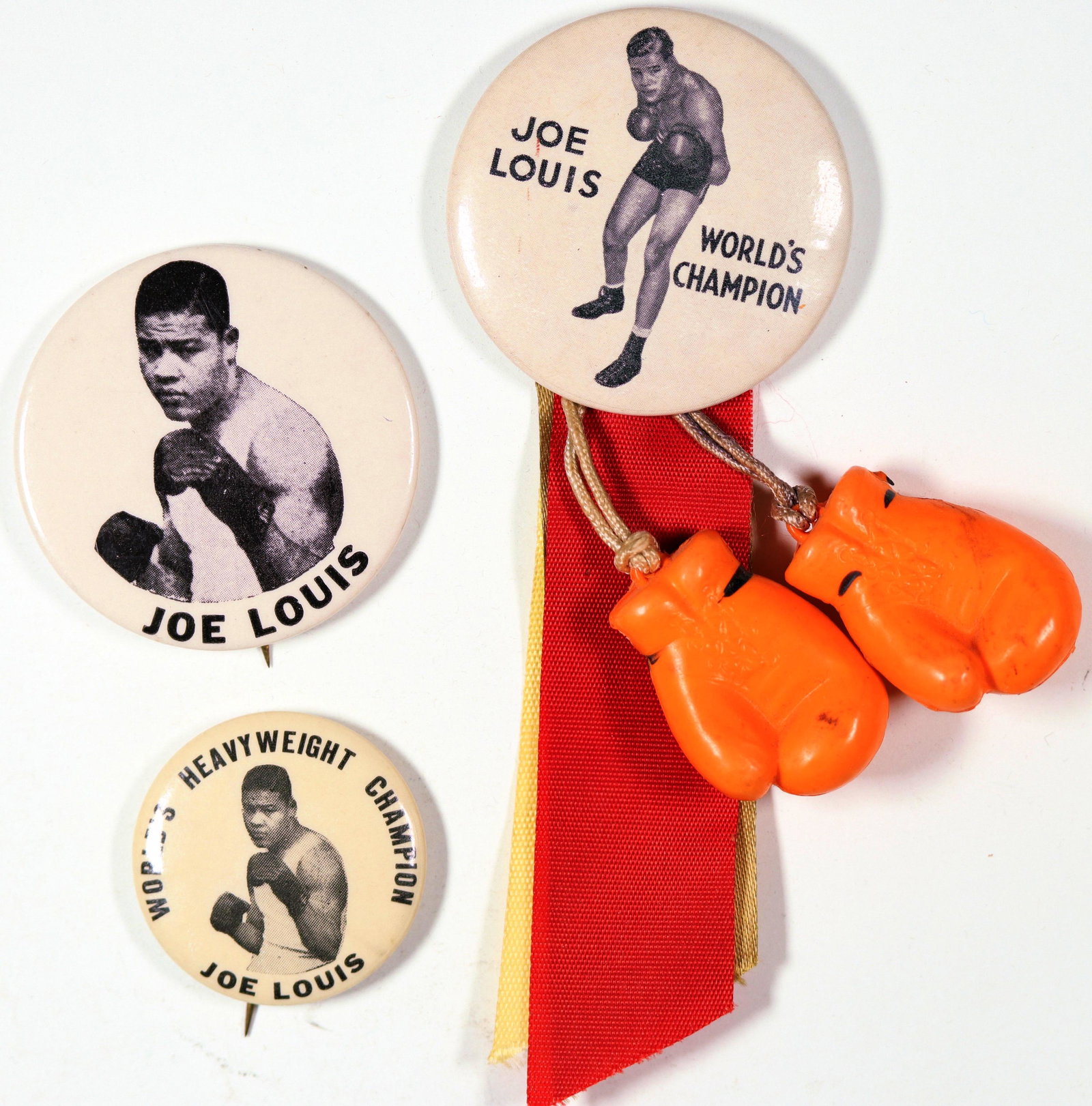 Joe Louis Boxing Photo Pins [129835]: Lot of three photo pins featuring heavyweight champion Joe Louis. Two are 44 mm, one with orange boxing gloves and red and gold ribbons attached. The other 32 mm. He reigned as the world heavyweight c