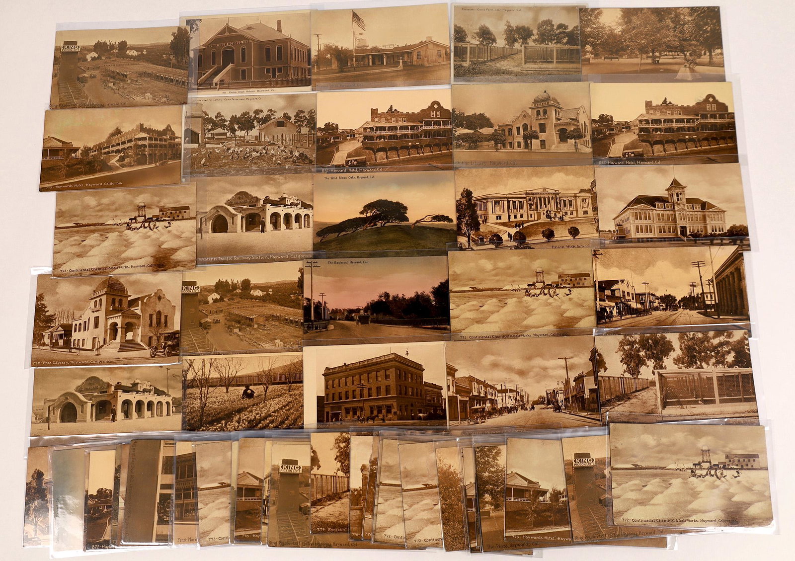 Hayward Amber Tint Real Photo Postcard Collection: Lot of 59 amber tint real photo postcards of Hayward California in the early 20th century. Most produced by Edward Mitchell of San Francisco. Street scenes, orchards, farms and notable buildings. Date