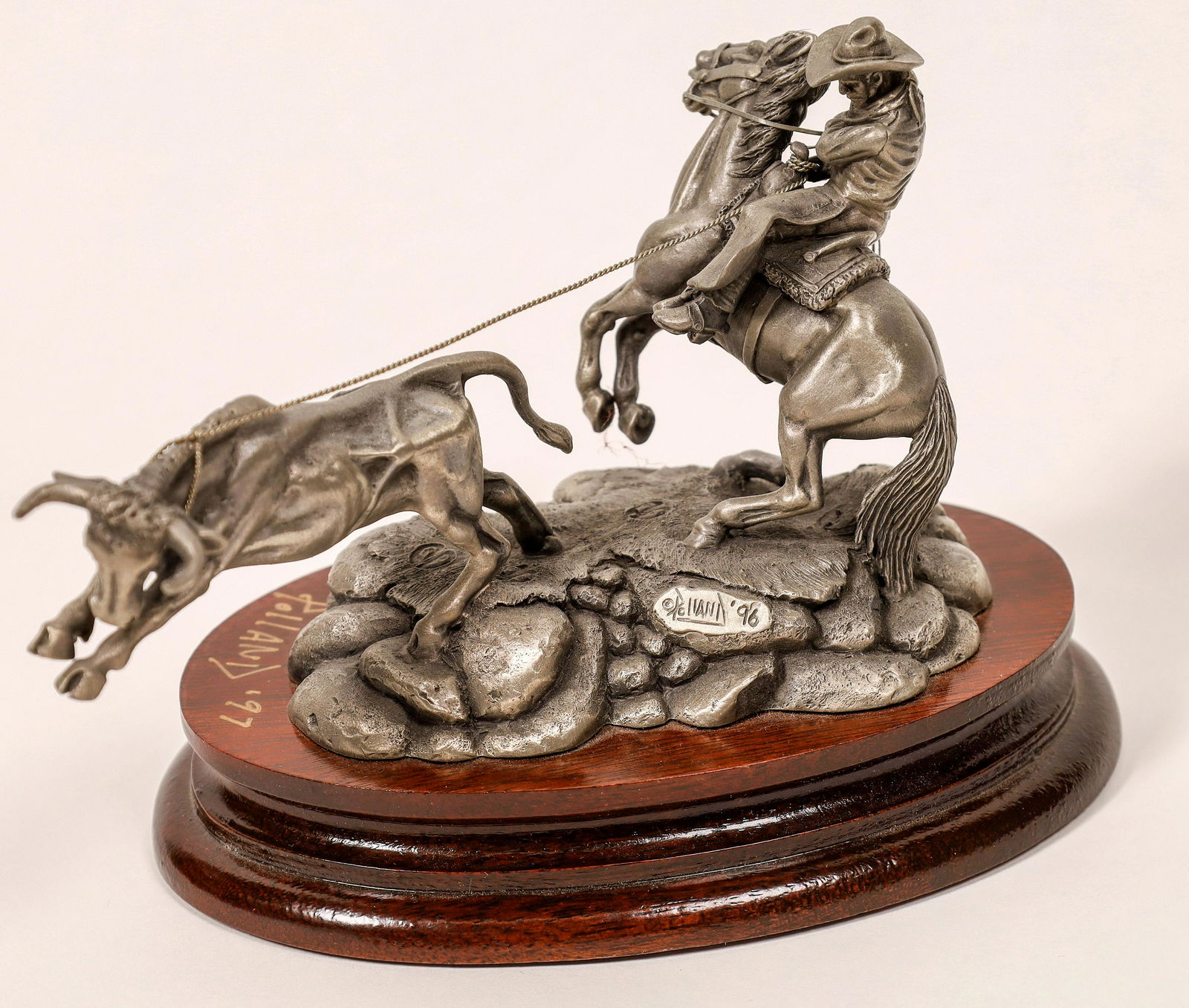 Chilmark GOTCHA! Pewter Sculpture Signed by Polland: Fine pewter sculpture, hand-signed on the wooden base in gold ink by artist Don Pollack depicting a cowboy lassoing a bull. New condition in original box. Medium-toned wooden oval base, approx 5-1/2 x