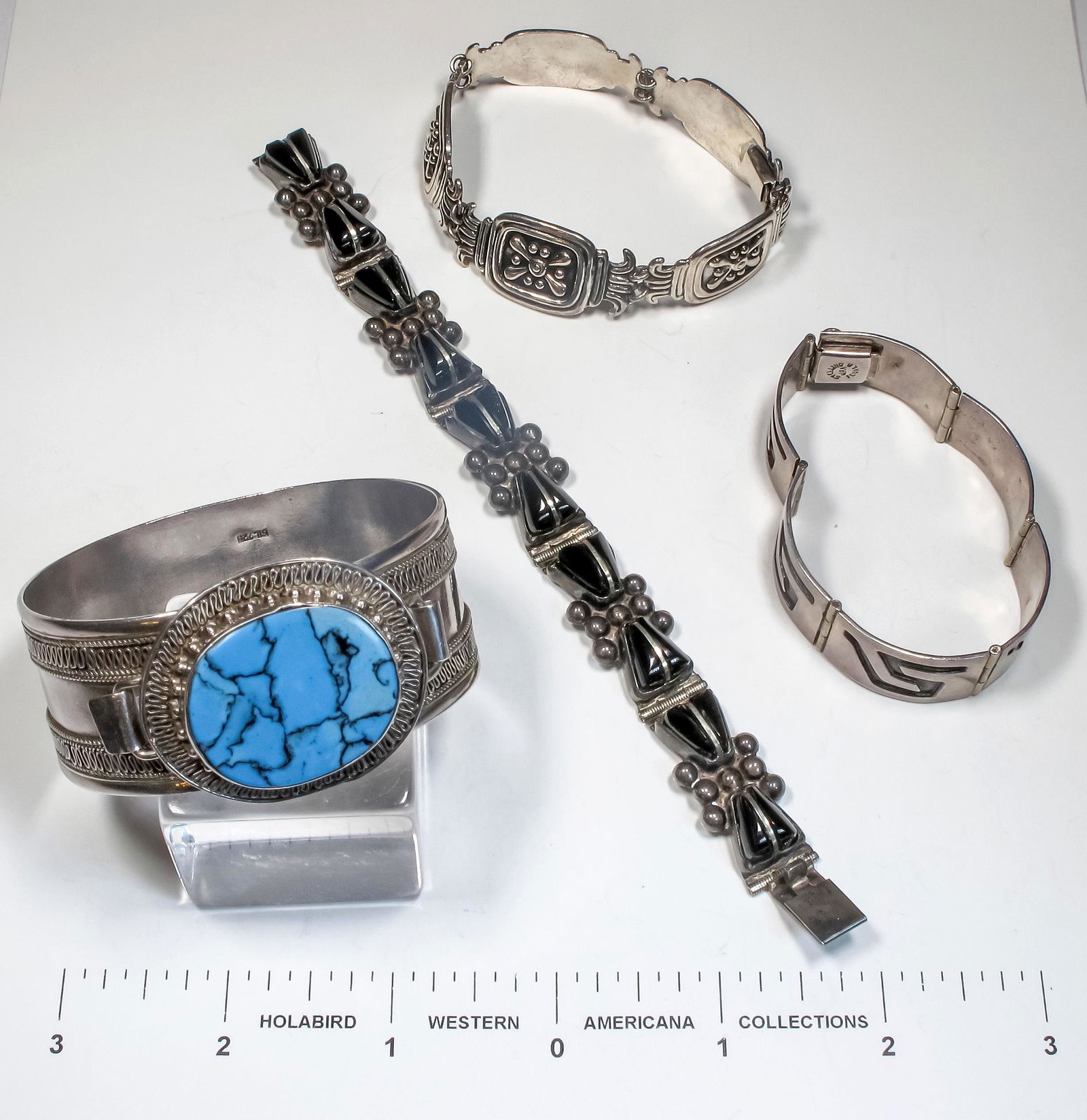 Four Antique Mexican Bracelets [124856]: Three beautiful silver link bracelets: one set with ten onyx cut stones; one incised silver (Hopi style); one silver designs on black ground. One cuff with applied silver filigree set with a large tur