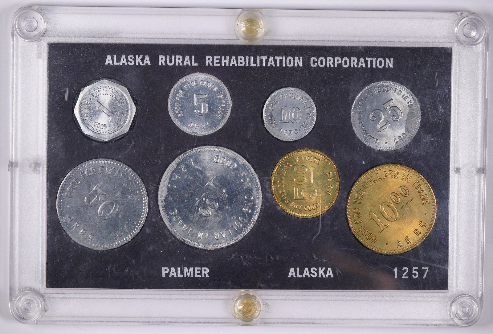 Alaska Rural Rehabilitation Corporation Token Set: Set of eight tokens from the Alaska rural rehabilitation Corporation, housed in a hard plastic holder. Issued for the 50th anniversary of the Matanuska Valley Alaska Colony Project. Good for 1, 5, 10,