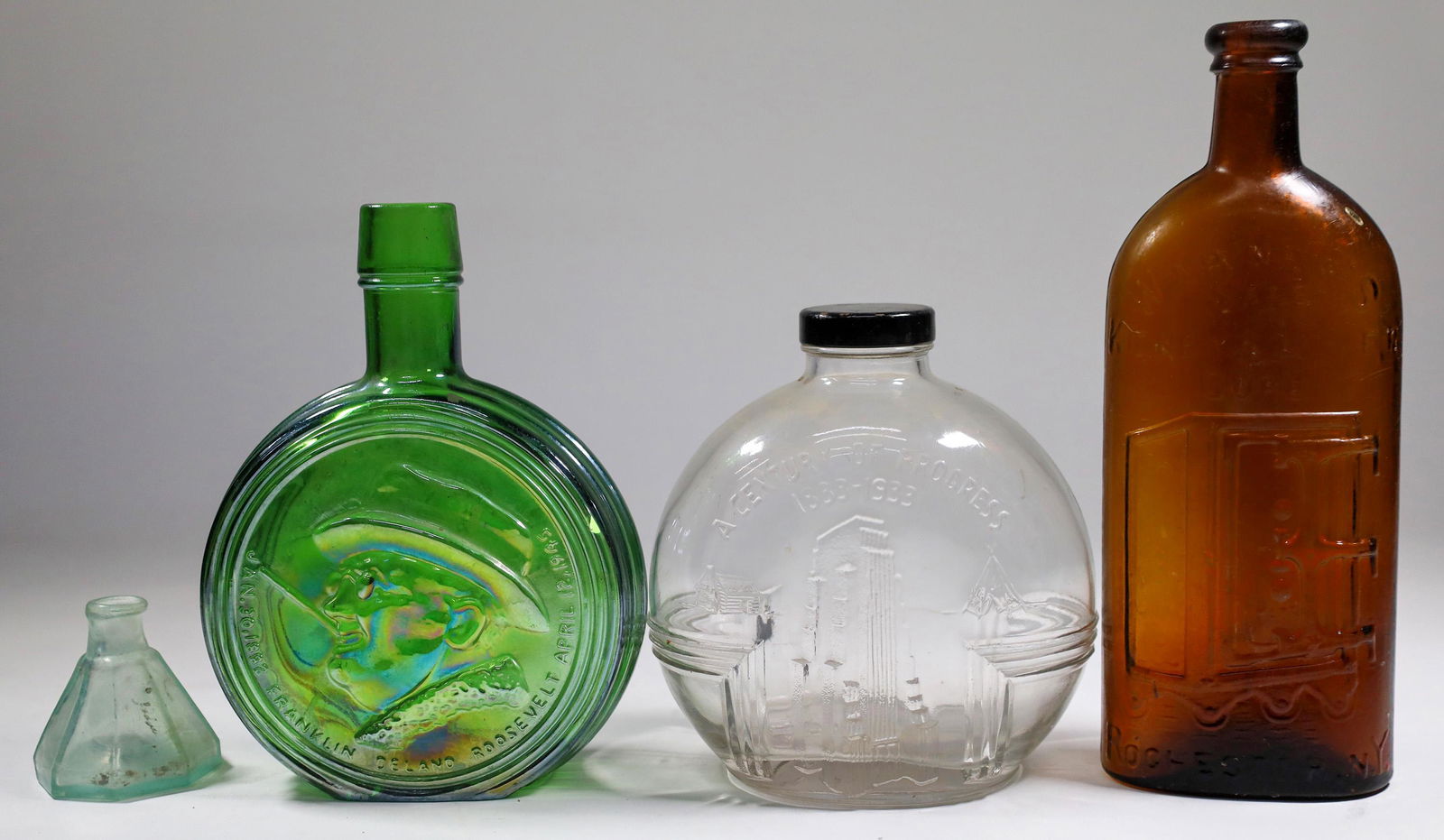 Roosevelt, Worlds Fair, Tonic & Ink Bottles [131972]: Group of four vintage bottles, including a 2"x 3" clear glass pentil umbrella ink, a 1933 6"x 6" Worlds Fair clear glass, an amber 10"x 4" tonic bottle and a reproduction of a Franklin Roosevelt comme