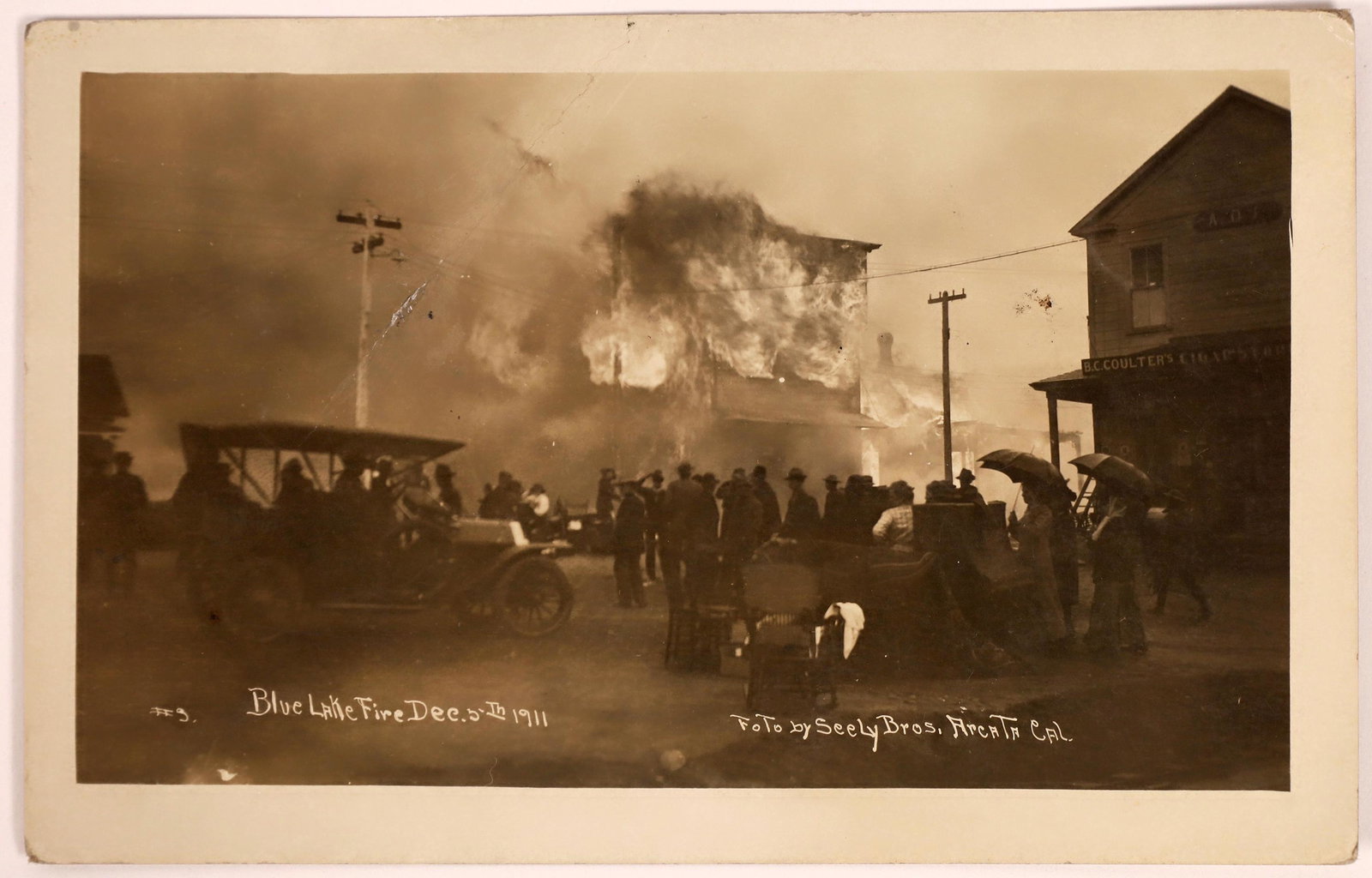 Blue Lake, California Fire Real Photo Postcard [134336]: Rare RPPC showing people watching a building engulfed in flames. Photo by Seely Bros., Arcata, Cal. Labelled "Blue Lake Fire Dec. 5th 1911." Mailed in 1912 to Napa (Blue Lake postmark). Large crease o