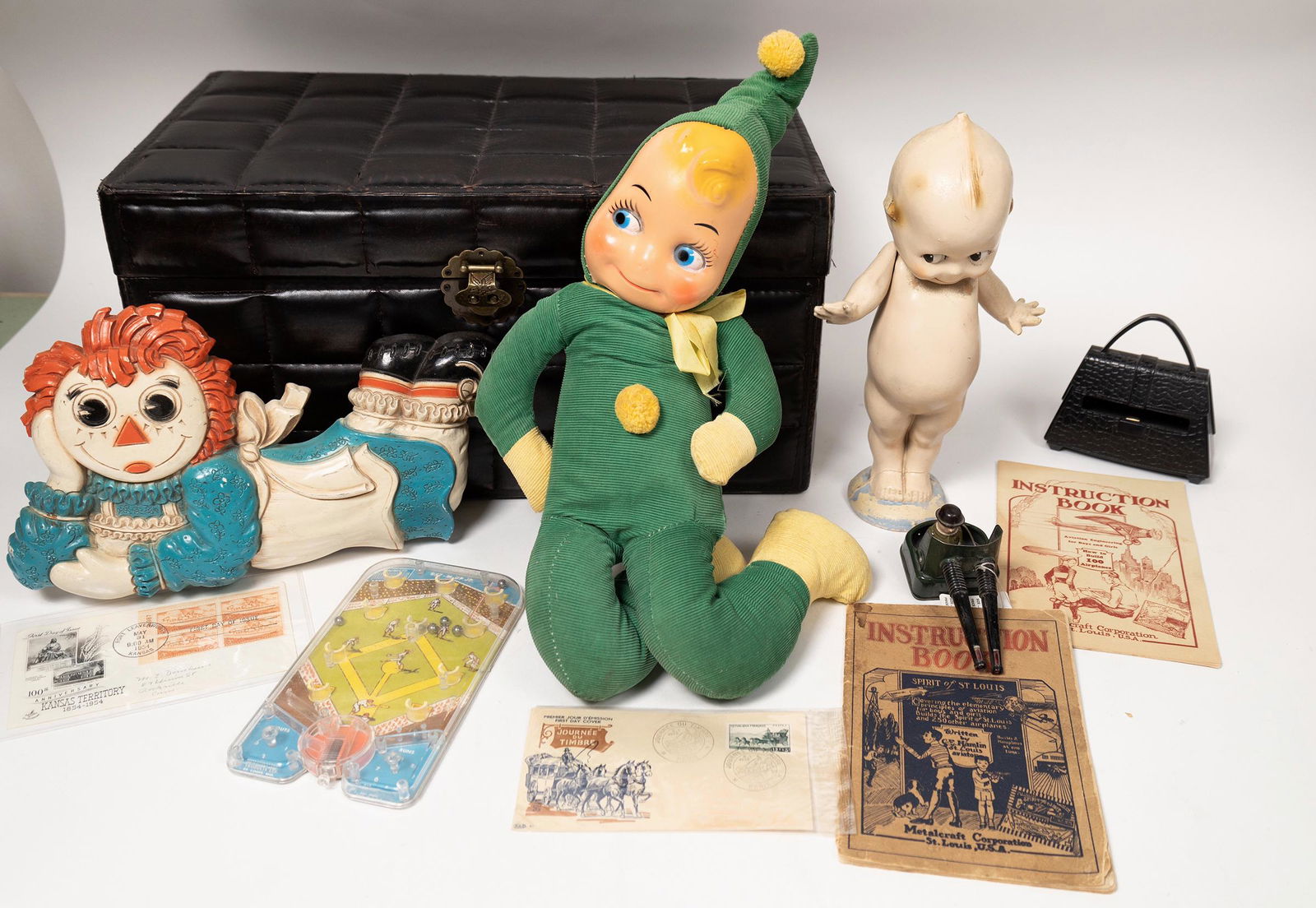 Toys and Kids Stuff [152871]: Metalcraft Corp. illustrated instruction books for model planes, 1928 and 1929. Bat-M-Up Jr. game. Raggety Ann wall hanging. Baby Doll, green doll. WW@ toy Army turret. Includes 9.5x11x11" padded carr