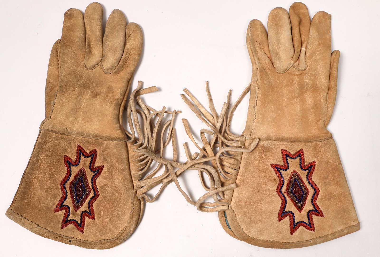 Geometric Bead Designs [152764]: Simple geometric designs in reds and black. Nez Perce gauntlets, approx. 13" in length. The clean design is unusual, but striking. Beading intact, gloves show wear. Date: Country (if not USA): State: 