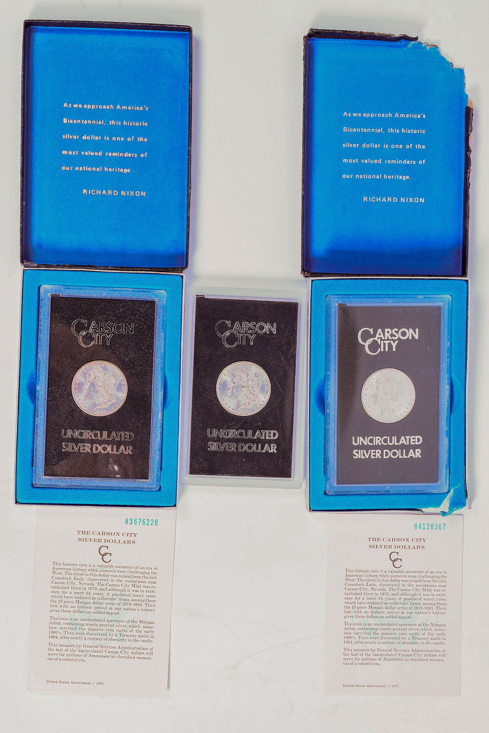 GSA Carson City Silver Dollars (3) [158164]: Lot of three GSA Carson City silver dollars. 1) 1884-CC no box or paperwork; 2) 1883-CC box and paperwork included, box lid detached, silver foil backing mostly missing; 3) 1884-CC with box and paperw