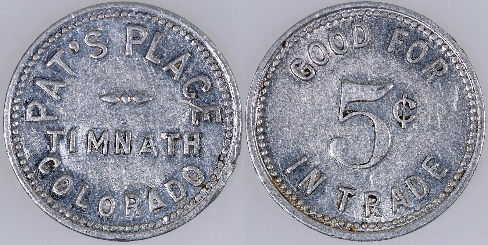 Pat's Place Token [159553]: Only token known from the Larimer County town of Timnath: PAT'S PLACE / TIMNATH / COLORADO // GOOD FOR / 5Â¢ / IN TRADE; al., rd., 23 mm.Date: Country: State: ColoradoCity: TimnathProvenance: Gary B