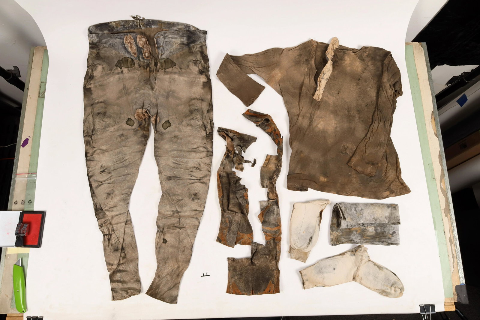 Men's Clothing, Easton Trunk, SS Central America Treasure [161748]: 5 articles recovered from the Easton trunk found at the S.S. Central America shipwreck. 1.) Ansel Easton's Undershirt. Heavy stain, silk reinforced button-down, which is offset to the right (not in th