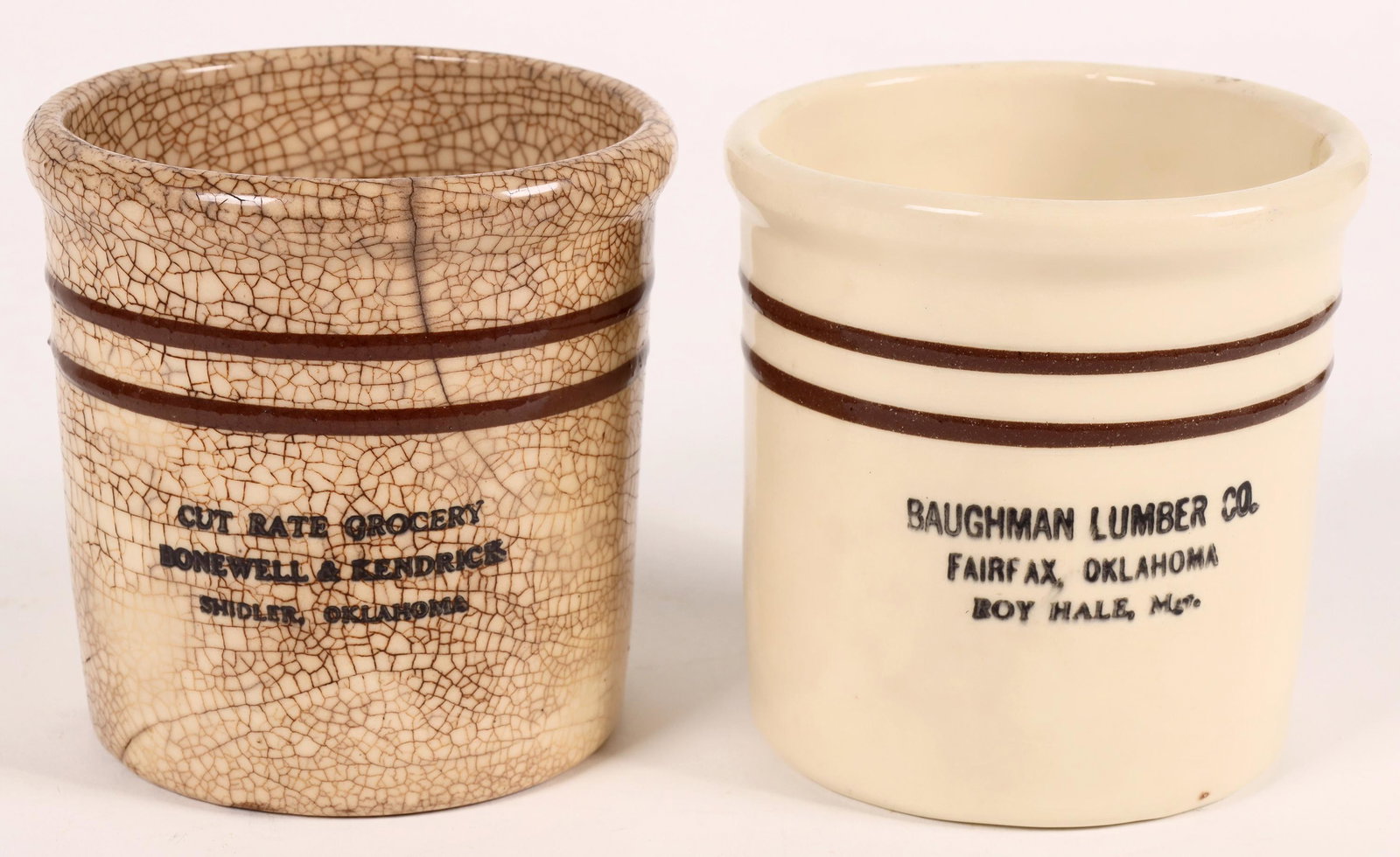 Oklahoma Advertising Pots, 2 [161367]: 2 small Oklahoma advertising pots. Cut Rate Grocery/Bonewell & Kendrick/Shidler, Oklahoma, 2 brown bands, 3 large cracks, overall glaze cracking. 4.75x4.5". Baughman Lumber Co./Fairfax, Oklahoma/Roy H