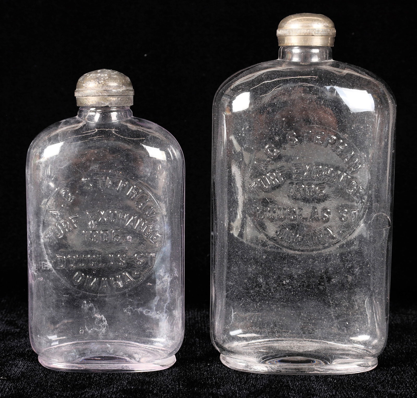 A C Stephan Whiskey Bottles, 2 [168333]: 2 clear A C Stephen/Turf Exchange/1306 Douglas St/Omaha whiskey bottles with metal screw tops. Pint and half pint. No apparent chips or cracks. Omaha Nebraska