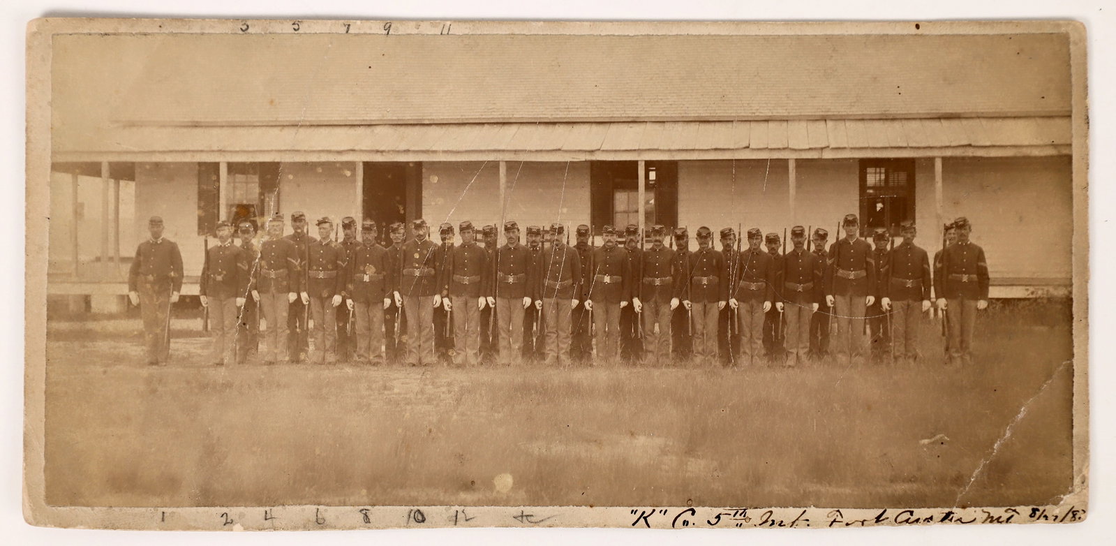 5th Infantry at barracks, Custer, Montana (1882) c1882 [171242]: Company [x=#8220/]K[x=#8221/], 5th Infantry at attention in front of their barracks at Fort Custer, Montana. Photo shows age and is a little light. Back has list of the soldiers (also light and diffic