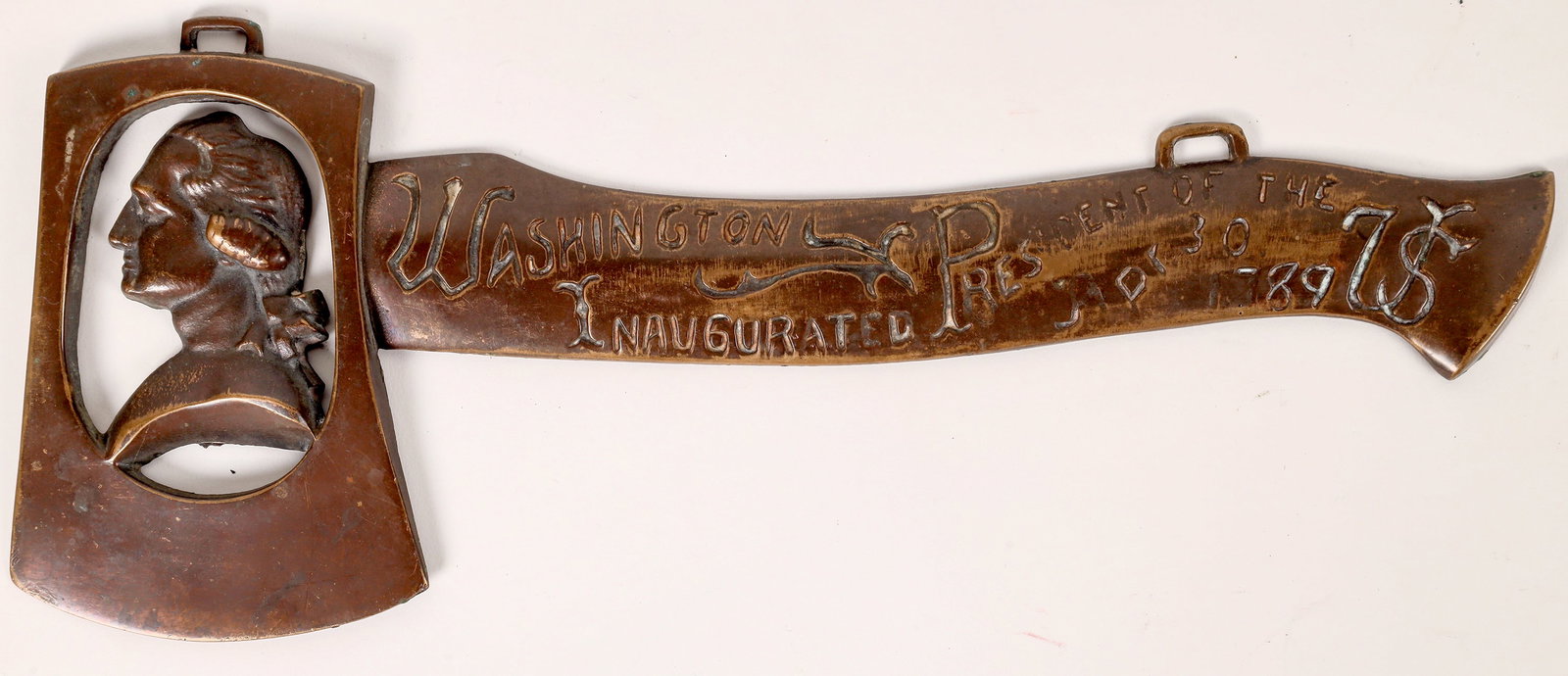 George Washington Souvenir Hatchet Relief Carved Brass 1789 [170412]: This brass hatchet in relief presents "Washington President of the US/ Inaugurated Ari. 30, 1789" with the likeness of George in the hatchet head. A cast brass with detailed relief two hanger loops at