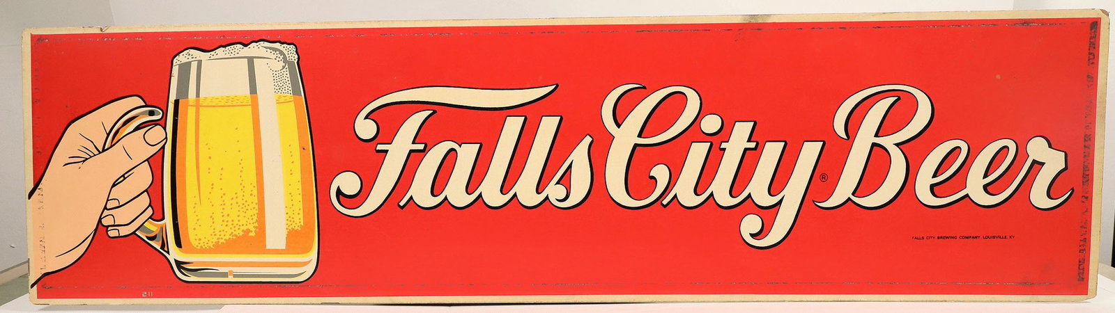 Fall City Beer Streetcar Advertising Sign [187925]: A vintage street car cardboard sign advertising Falls City Beer. Printed in white letters on a bright red background the sign shows an animated hand holding a beer stein and reads Falls City Beer. Fal