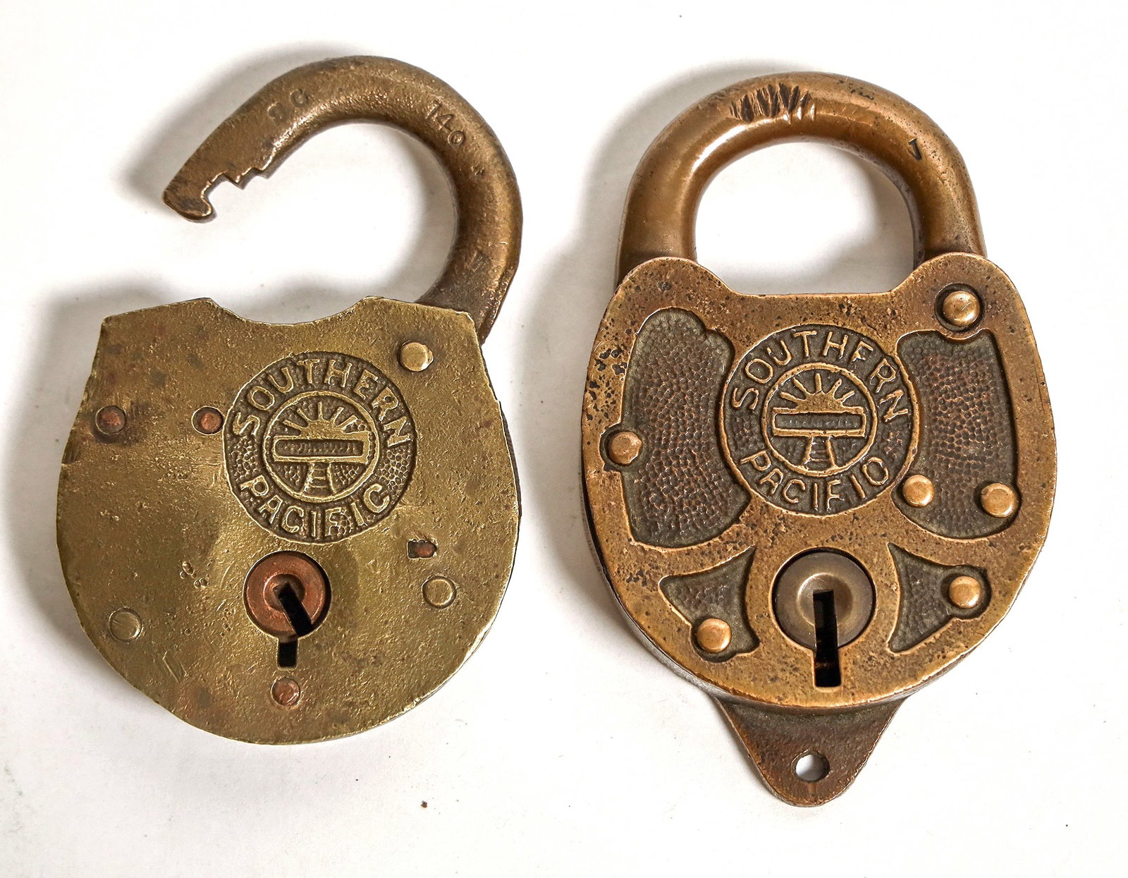 Southern Pacific Railway Locks w/ Sunset Logo (2) [191206]: A pair of brass locks from the Southern Pacific Transportation Company. Both locks bear Southern Pacific's logo, depicting the setting sun on the horizon over a railroad track and the words 'SOUTHERN 