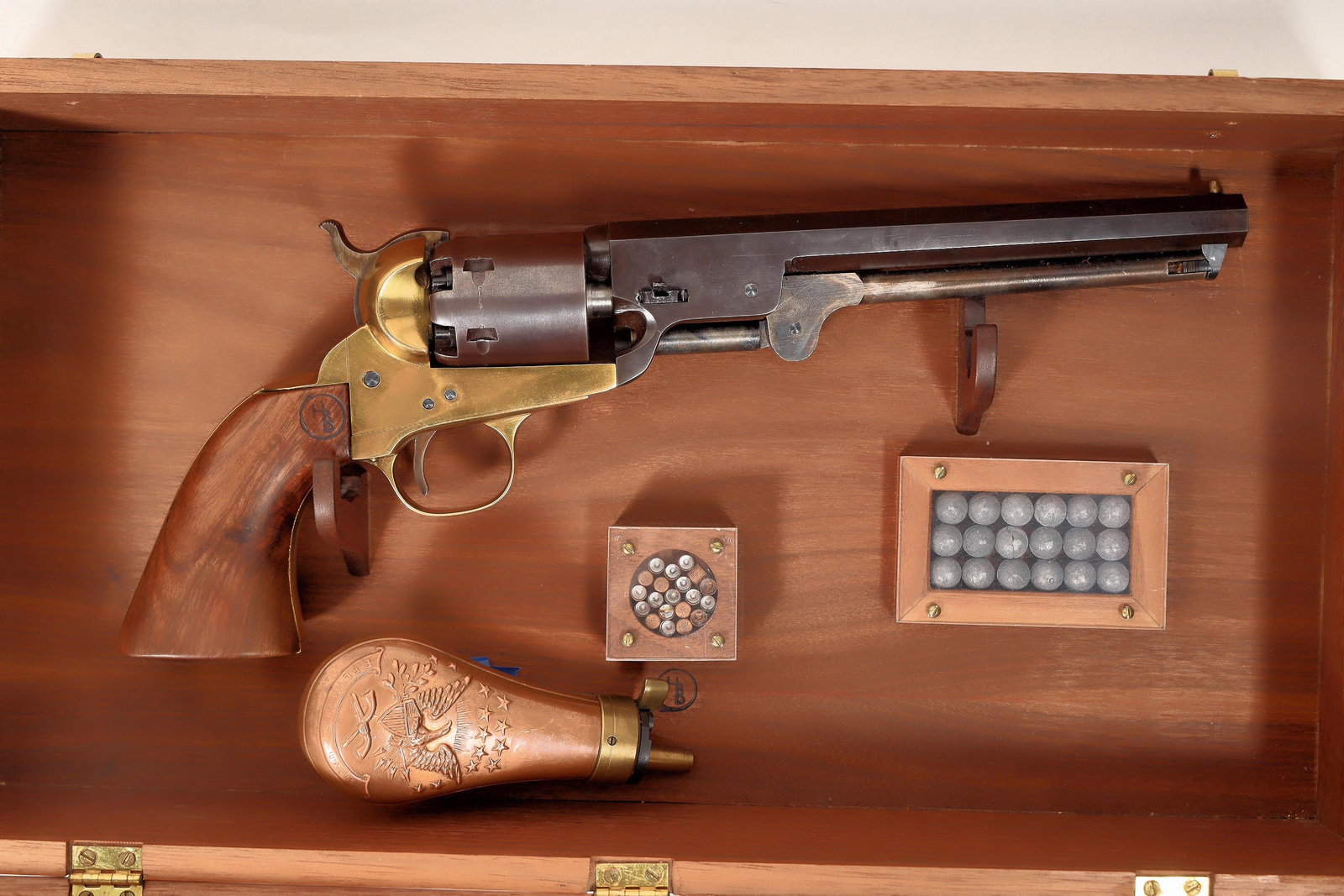 Replica Colt 1851 Revolver in a Shadowbox [189850]: This shadow-box includes an 1851 Navy Colt replica. There is no serial number on the firearm and there is a brand mark on the grips "HP". It is nicely finished in brass, walnut and a plum colored blui