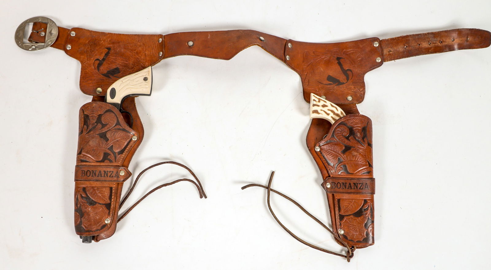 Bonanza Toy Cap Gun and Holster set [196964]: This is a Hubley "Bonanza" cap pistol rig with two cap pistols and Bonanza marked holsters. The guns are one short barreled pistol and one long barreled pistol in black and imitation ivory grips. The