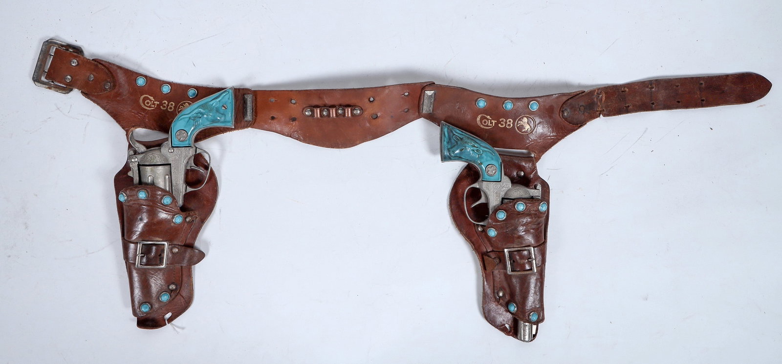 Hubley Colt 38 Cap Pistols with Holster Set 1950's [196327]: These cap pistols are marked Colt 38 with the rampant colt logos in top grain saddle leather holsters. One pistol is missing the hammer. Both guns have imitation turquoise grips with turquoise buttons