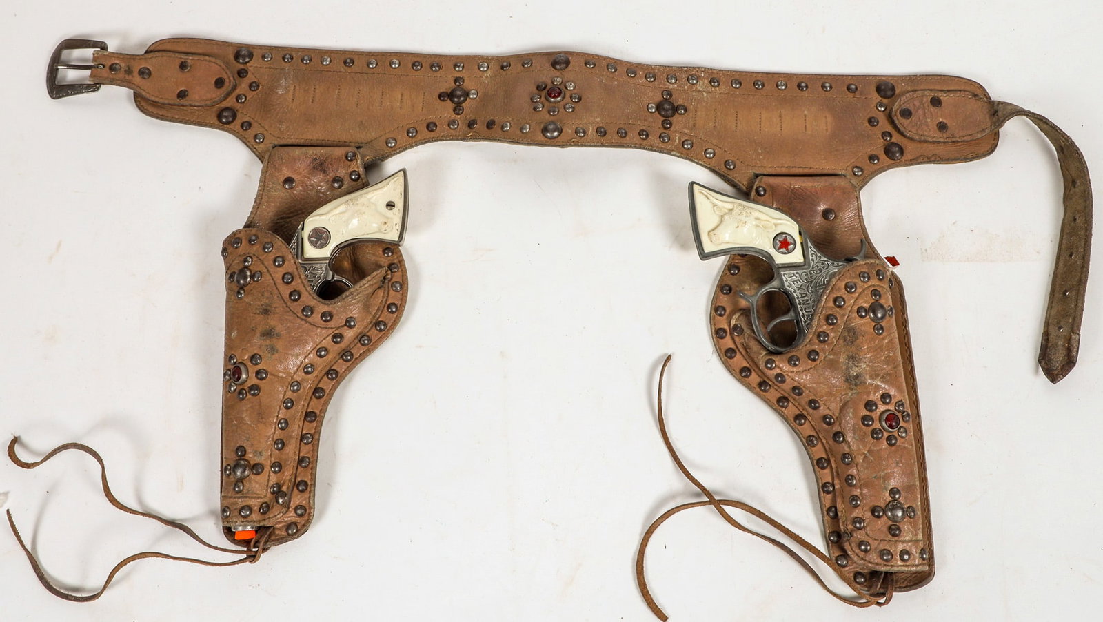 Two "Texas Jr." Cap Pistols in LH Brand Holsters [196980]: There are two Hubley "Texas Jr." cap pistols set into two LH Brand leather holsters and belt. The belt bullet loops now gone. The leather is very supple. Gun in good condition. Please see photo for de