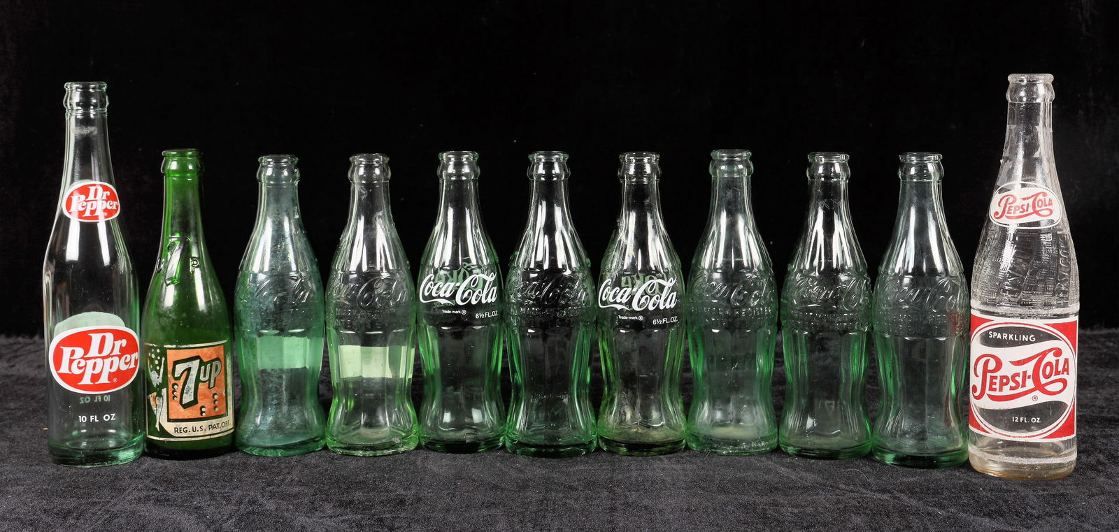 Reno Soda Bottle Collection, 11 [195399]: 11 Reno soda bottles. Coke-2 newer, the best are 4 varieties of Christmas, large and small "D". Pepsi, 7 Up and Dr Pepper. No apparent chips or cracks. See photo. ^ Date: Country (if not USA): State: