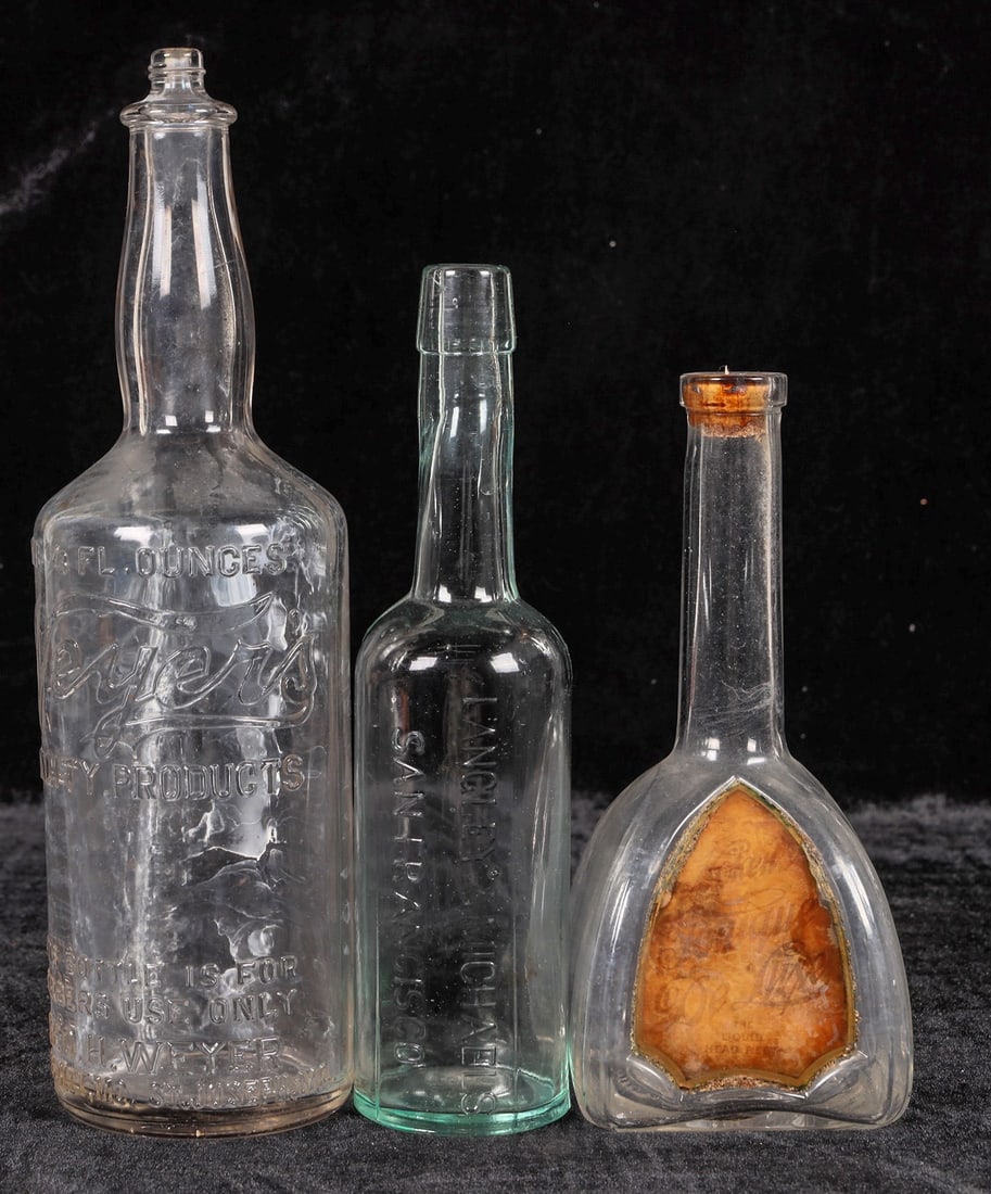 Barber Shop Bottle Trio [195383]: Light aqua 8.75" Langley & Michaels/San Francisco perfume bottle, 7.25" clear with label under glass, 10.75" clear Geo H Weyer. No apparent chips or cracks.^Date: Country (if not USA):State: City: Pro