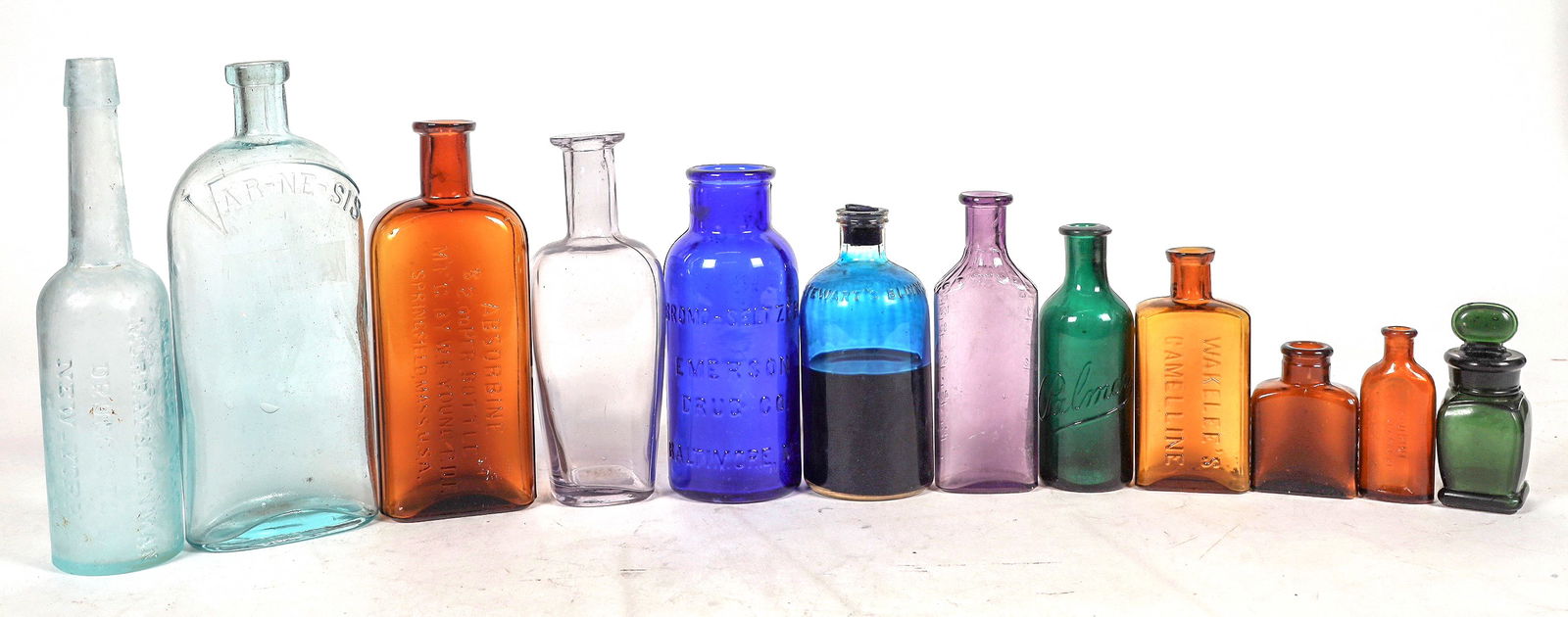 Bathroom Bottles, 12 [195558]: 12 bathroom bottles, 3.25-8.75". Aqua, cobalt, teal, green, clear. See photo. No apparent chips or cracks.^Date: Country (if not USA):State: City: Provenance: Mike Polak "Bottle King" CollectionPLEASE