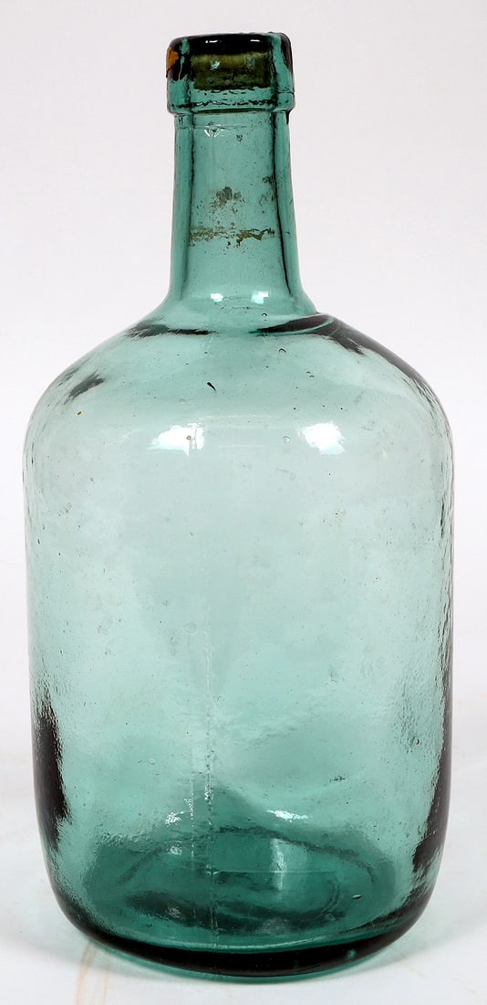 Beautiful Deep Aqua Demijohn (1870's) [195940]: A gorgeous deep blue demijohn from the 1870's. Applied tap, lots of whittle, partial original wax seal. This piece measures 12.5" tall, 5" diameter and has a 1.25" scratch on the bottom face and anoth