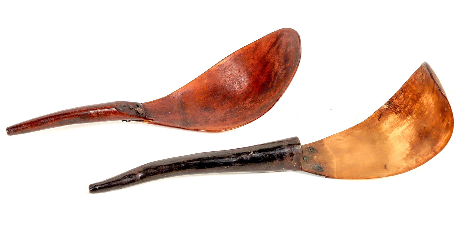 Haida Goat Horn Feast Spoon Pair [197073]: 2 different c. 1840-60 Haida goat horn feast spoons. Darker patina, 8x2.25"-1 empty attachment hole, some bone loss near handle, 2 different attachment materials. Lighter patina, 9x2.5"-drilled? hole 