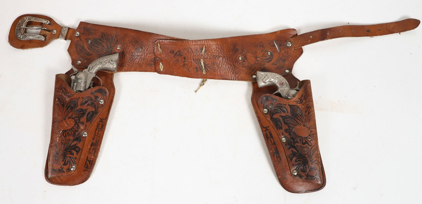 Top Gun Hubley and Star Cap Gun and Holster set [196963]: This Top Gun set includes one Hubley Chief cap pistol and one Star pistol. The Hubley Chief is not working. The leather holster and belt is top grain leather in two tone tooling. Please see photo for