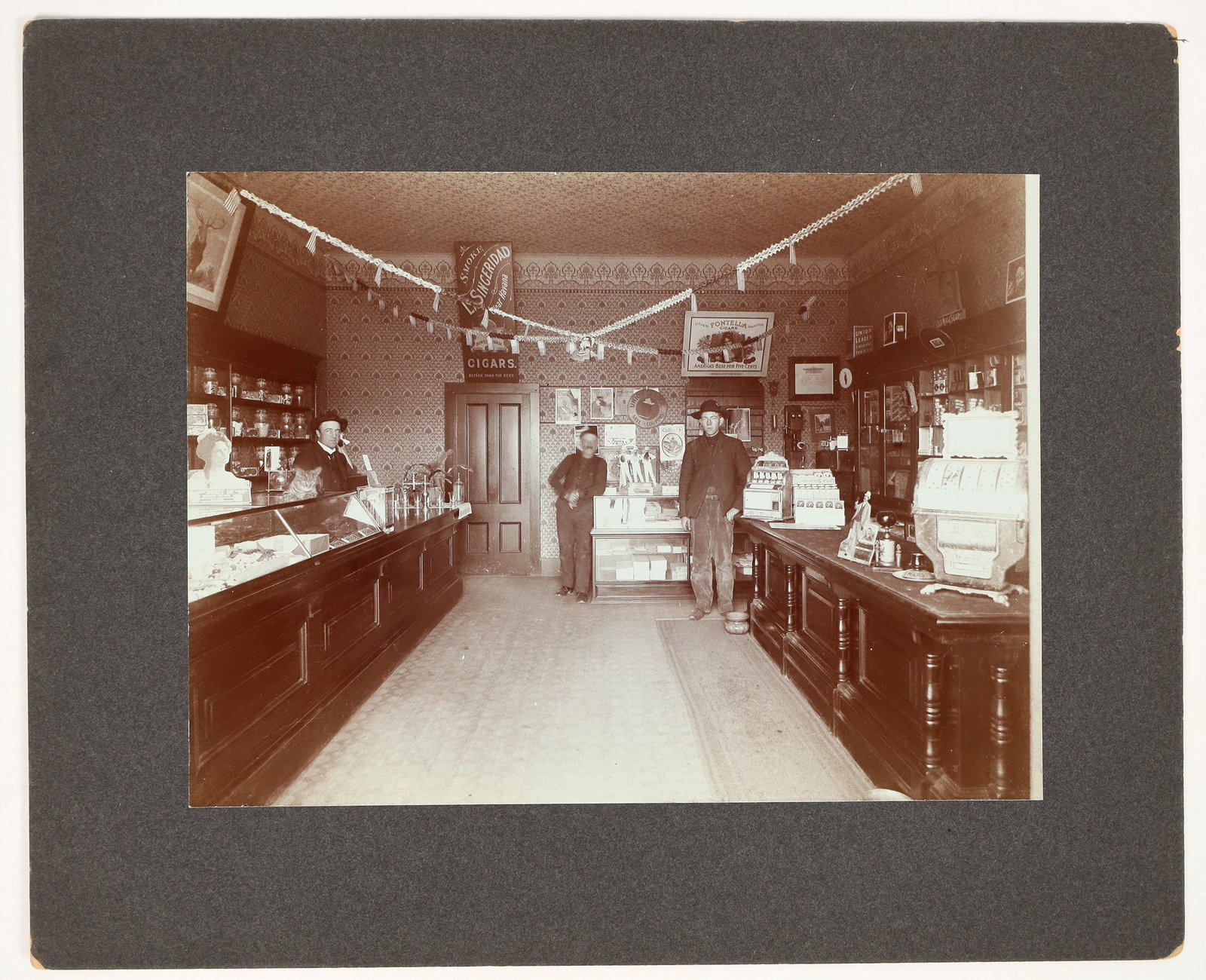 San Francisco Cigar Store Photograph c.1900's [197243]: This San Francisco cigar store was built in the old saloon style. In the photo you will find two draw card poker machines; the one in the back is a vintage 1904 Mills Draw Poker machine. There are sev