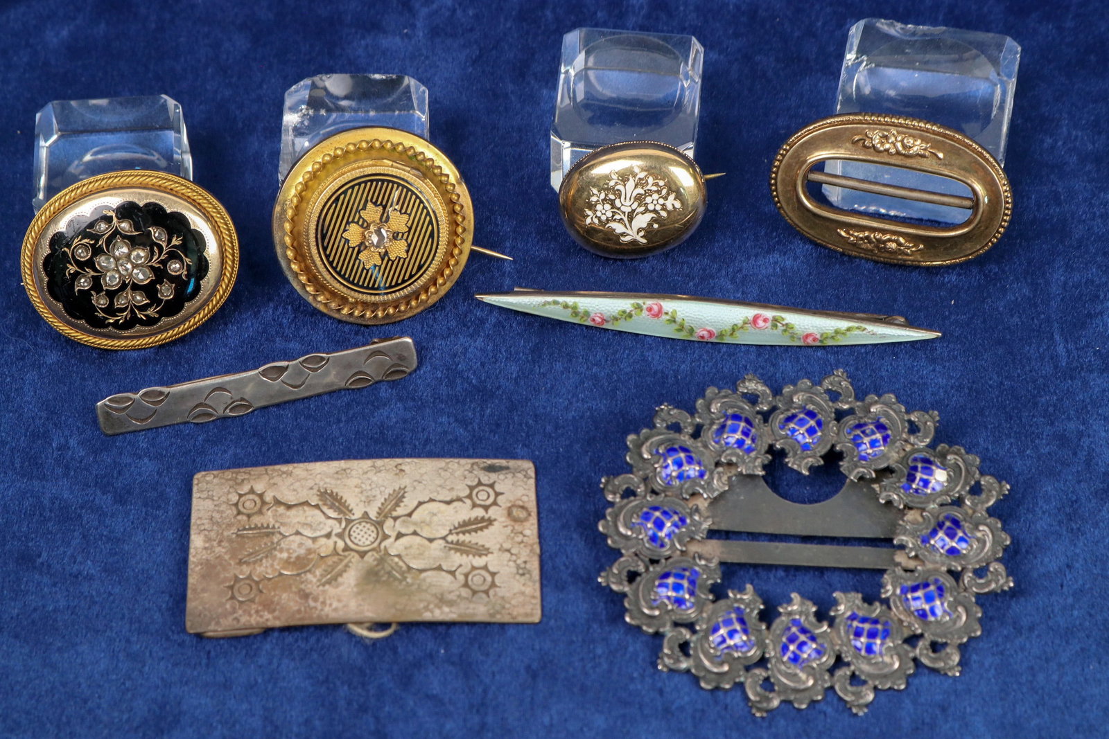 Brooches/Clips [124974]: 8 pieces, one marked sterling. Engraved design on Anna Maccieri Rossi pin. 5 pieces are gold toned all with floral designs--elongated enamel painted oval, 3 rounded ovals, one scarf holder. one belt b