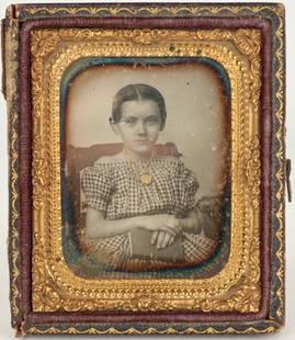 Daguerreotype - Child's Photo, c1850s [190116]: Daguerreotype of a young girl in a gingham dress holding a book, wearing a colored gold necklace. Possible California Gold Rush era, c1850s. Gold gilt frame with tooled leather backing. One-half of th