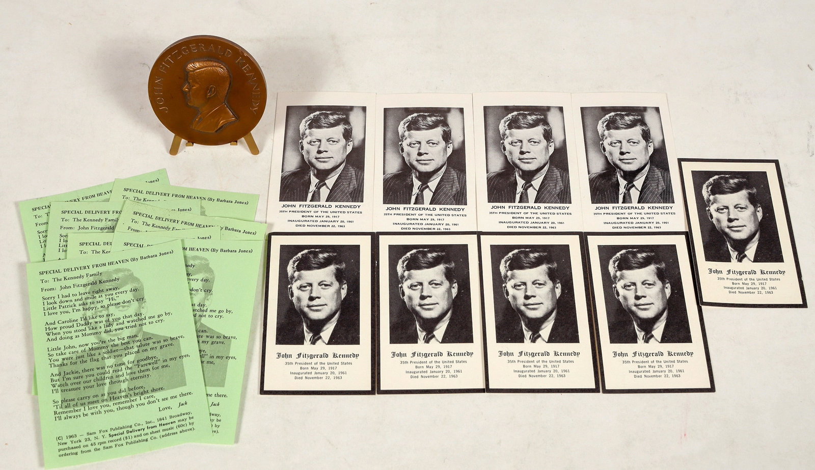 John F. Kennedy Memorabilia Cards and Inauguration Medal [200147]: There is one bronze Inauguration Medal for JFK with stand produced by the Medallic Art Co. designed by Paul Manship (2.75 in. diameter). In very good condition. Four JFK funeral prayer cards without a